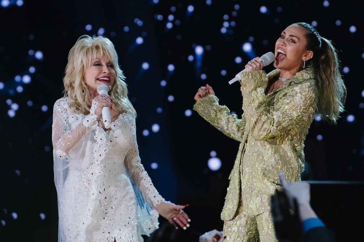 Dolly Parton and Miley Cyrus perform together on stage.