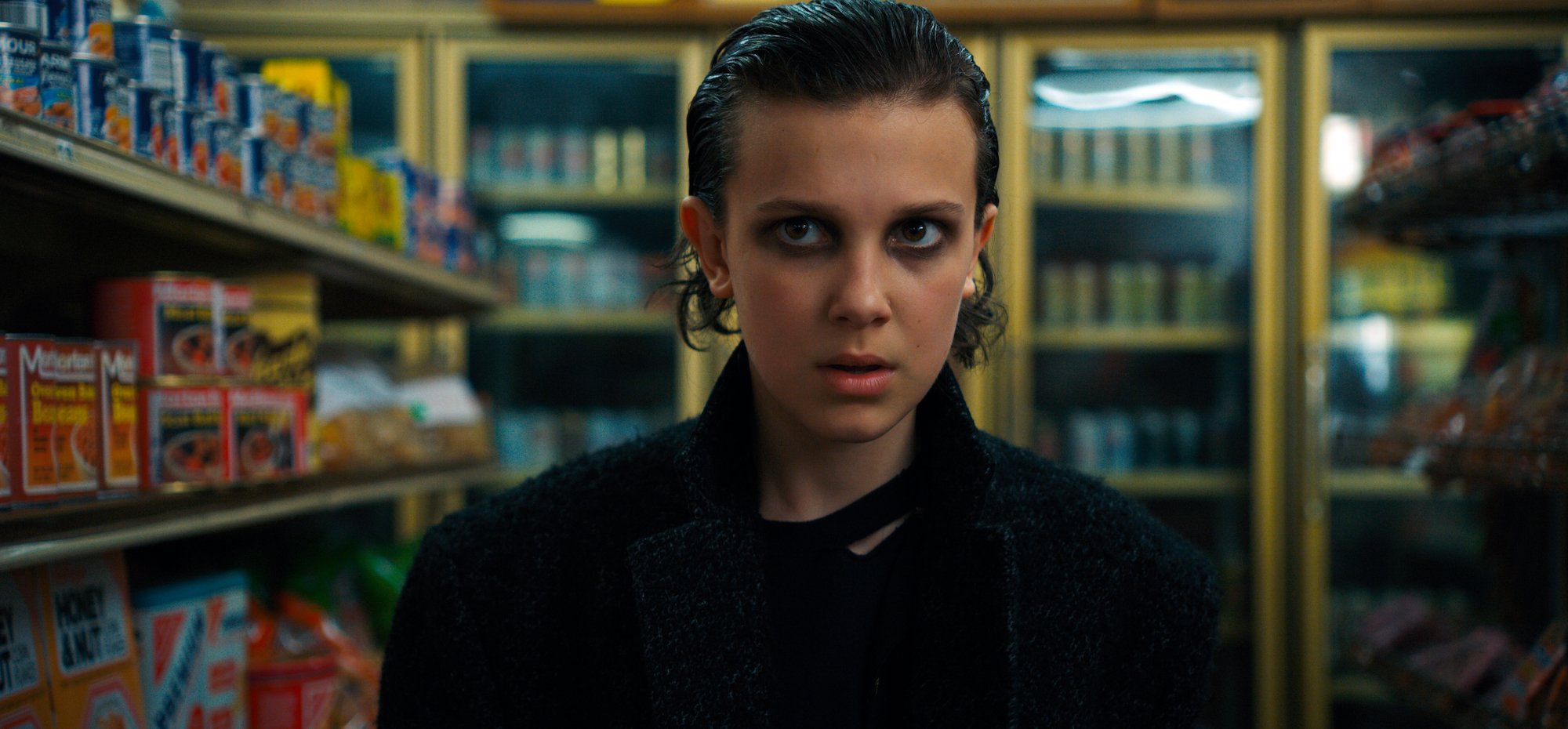 Eleven from 'Stranger Things' Season 2 in a black leather jacket with black eyeliner smudged around her eyes.