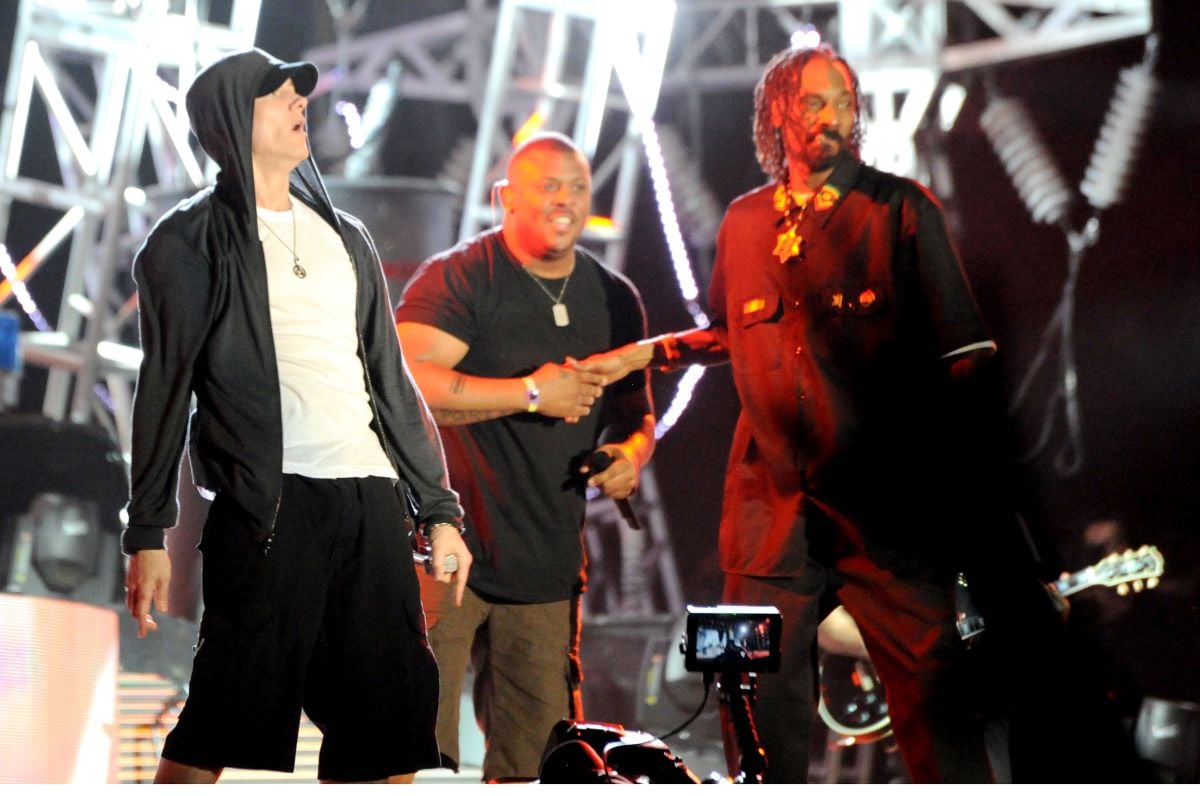 Eminem in a black hoodie and cap, onstage with Snoop Dogg in a black shirt