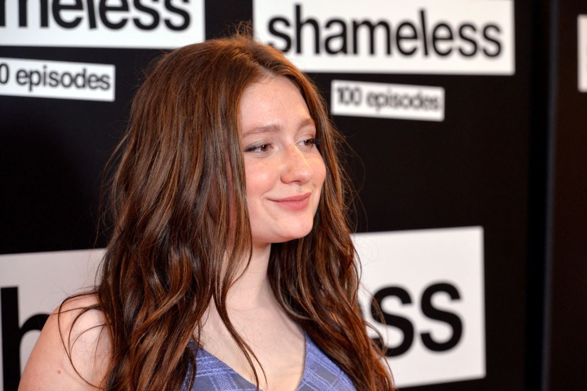 Emma Kenney with hair down, looking away from camera and smiling