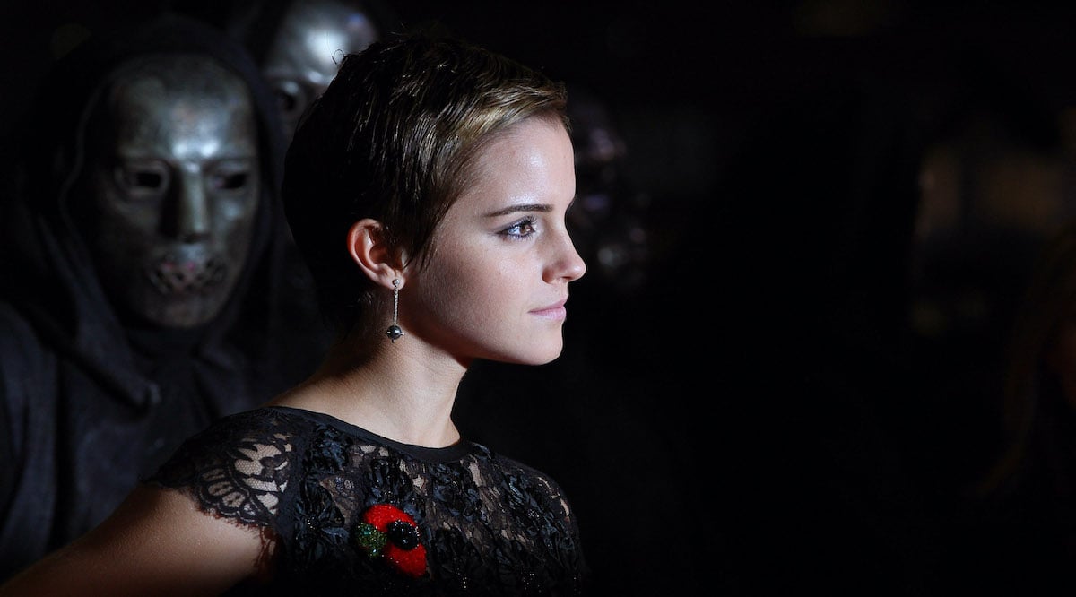 Emma Watson with short hair posing in a black dress at a movie premiere