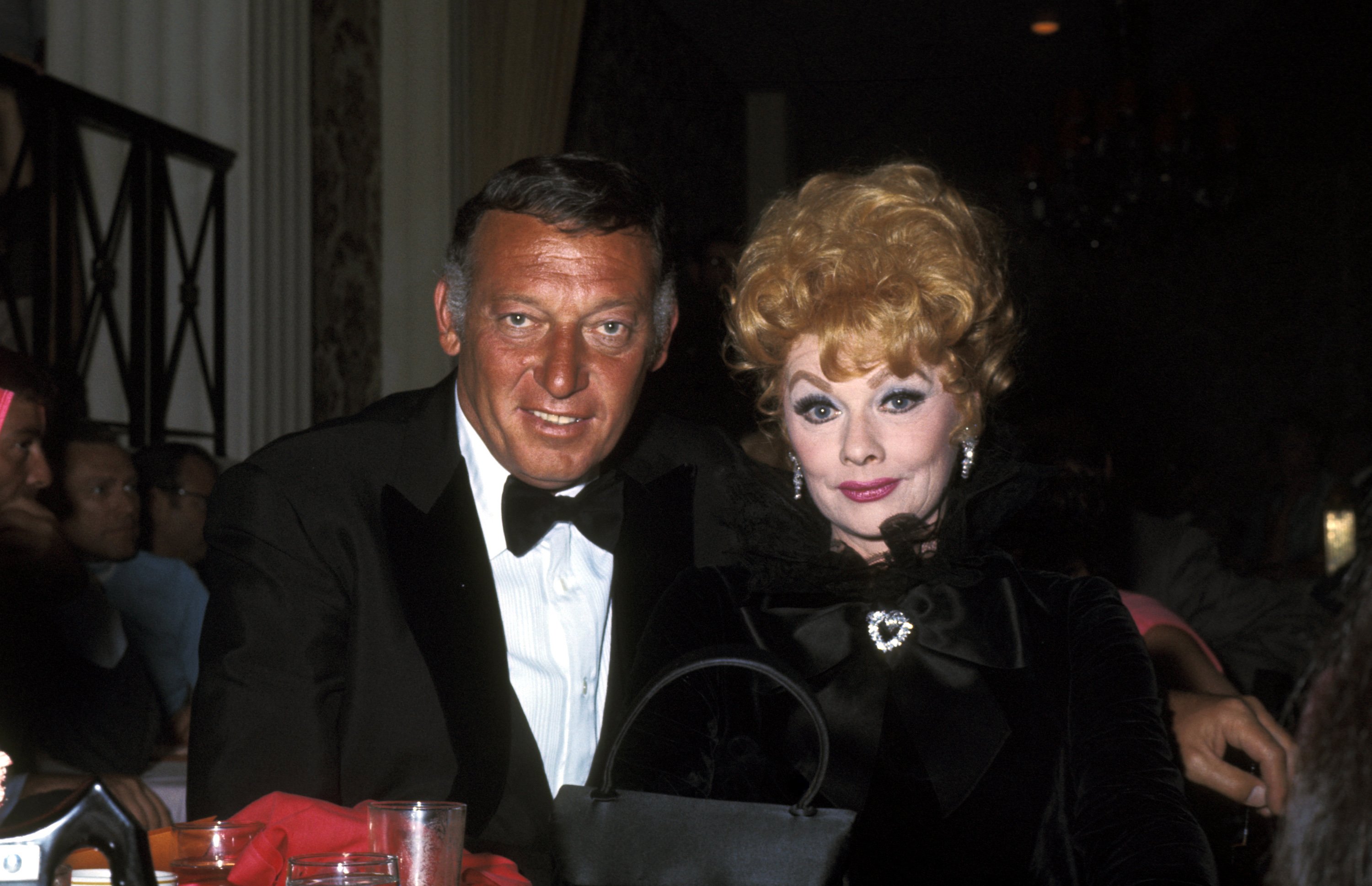 Gary Morton and Lucille Ball pose for pictures wearing black attire 