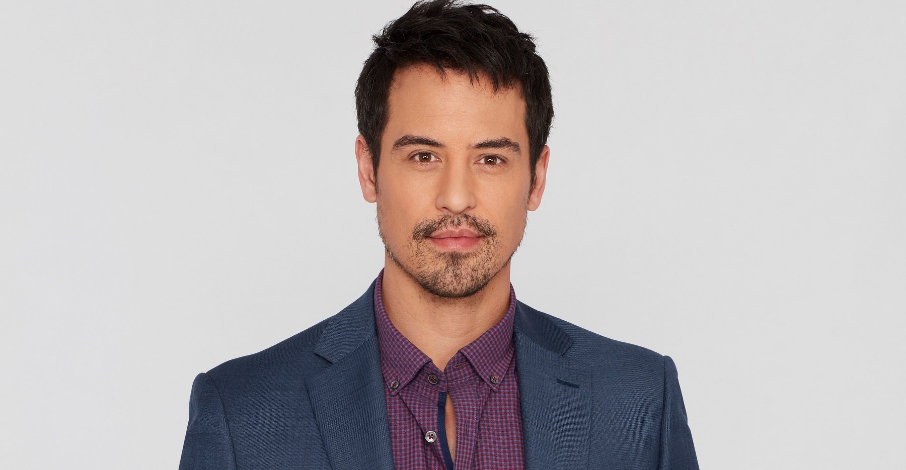 General Hospital Comings and Goings feature Marcus Coloma, pictured here in a grey jacket and purple shirt