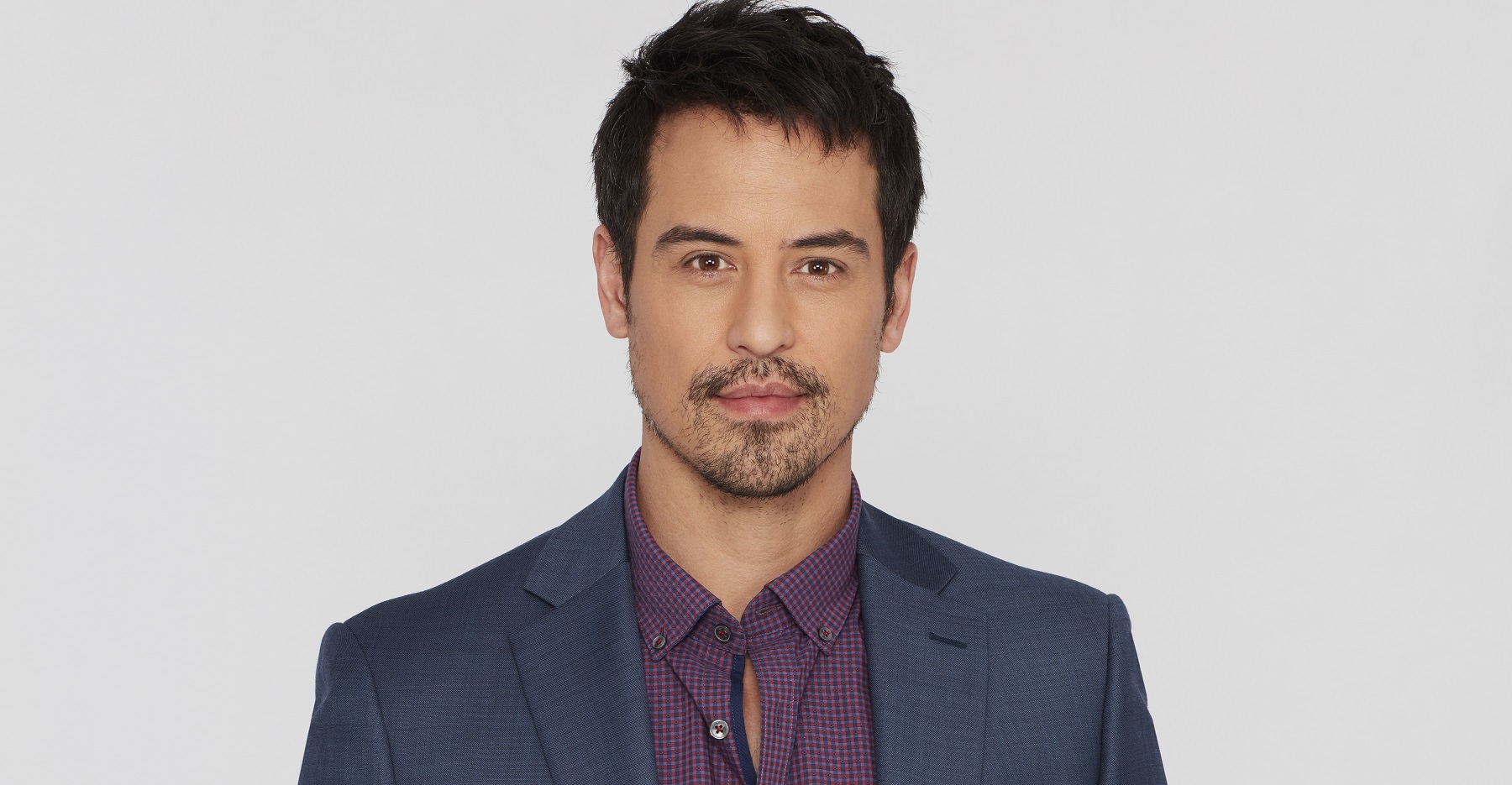 General Hospital Comings and Goings feature Marcus Coloma, pictured here in a grey jacket and purple shirt