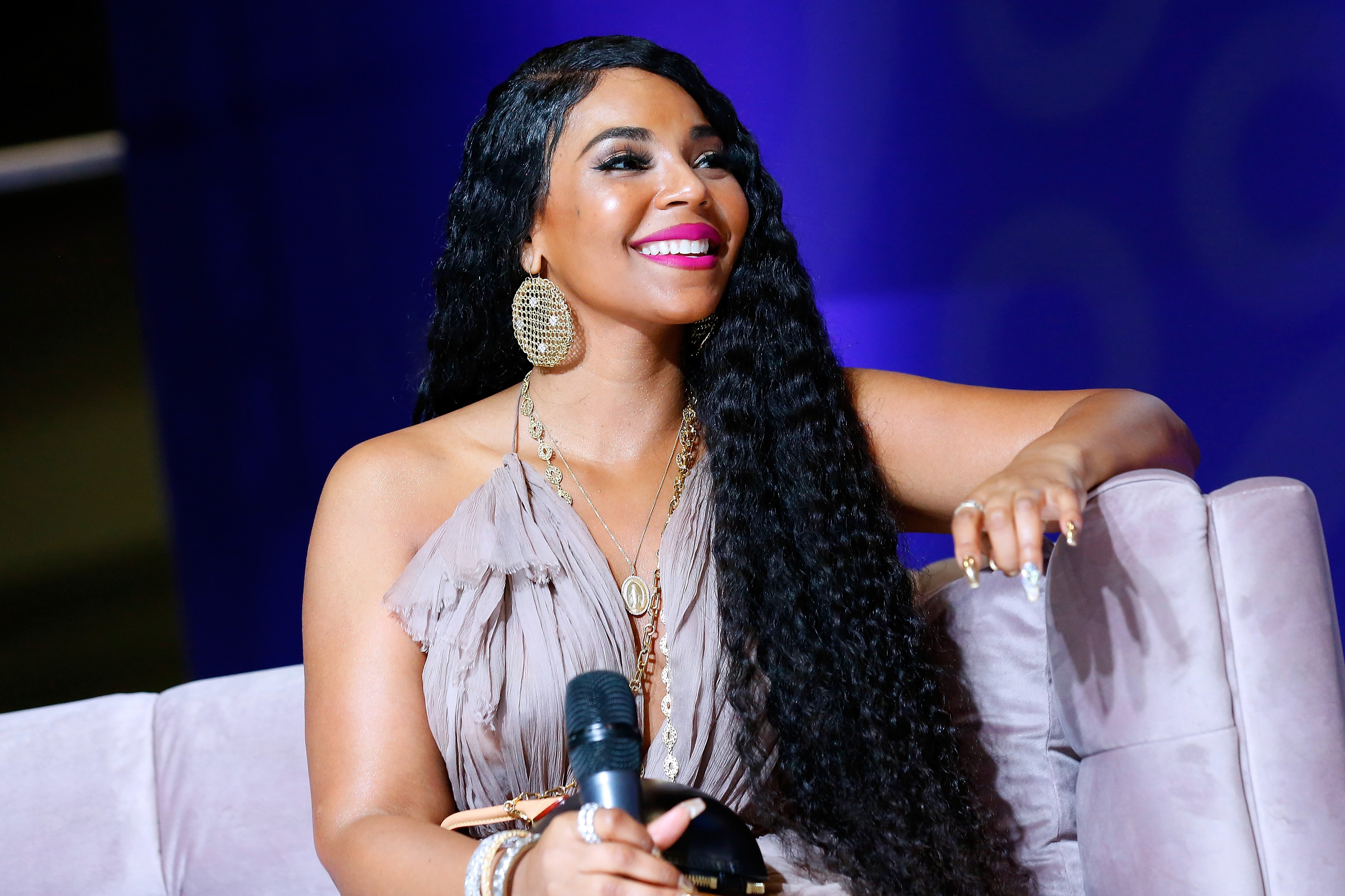 Ashanti smiling wearing a silver dress