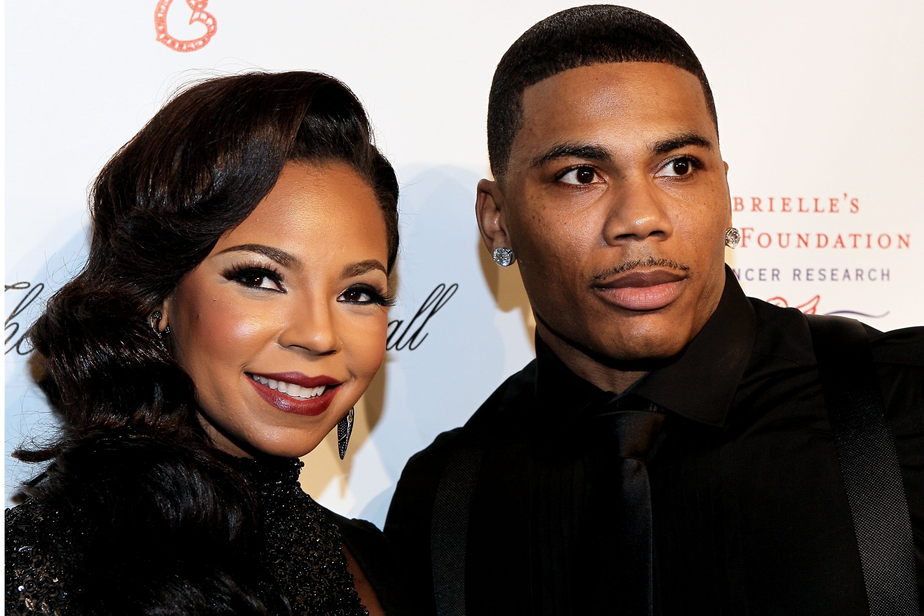 Ashanti and Nelly smiling and wearing black