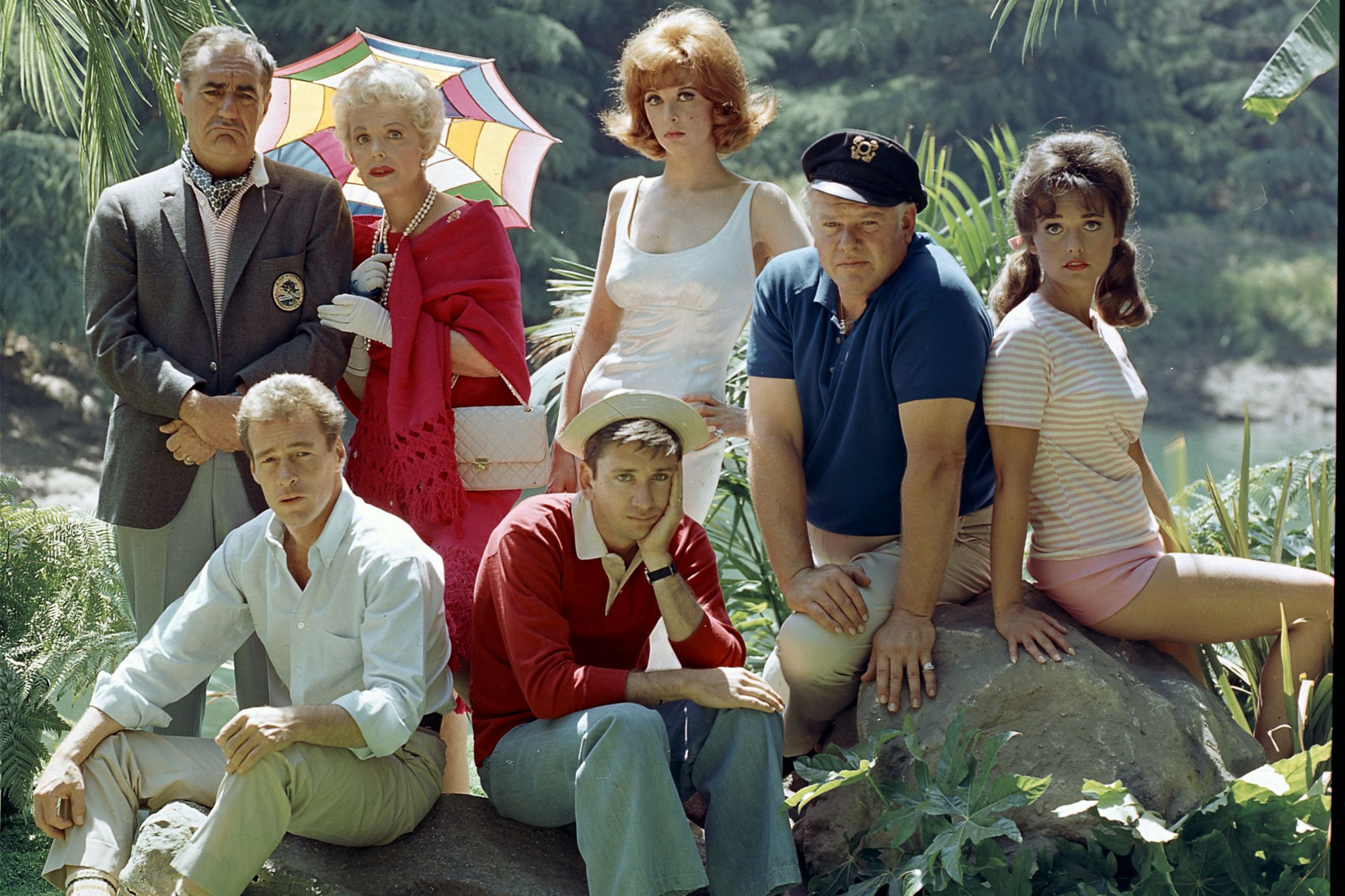 'Gilligan's Island' cast Jim Backus, Natalie Schafer, Tina Louise, Alan Hale Jr, Dawn Wells, Russell Johnson, and Bob Denver sitting on rocks