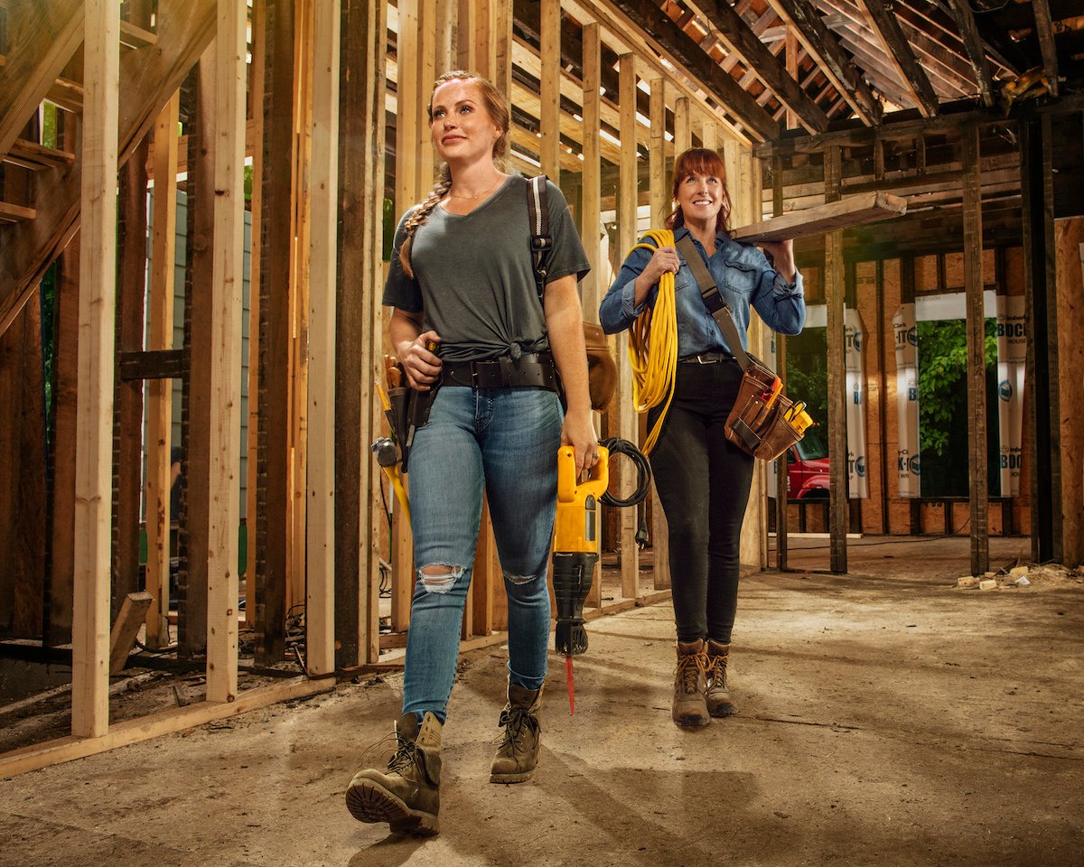 Karen E. Laine and Mina Starsiak walking through a stripped house holding power tools
