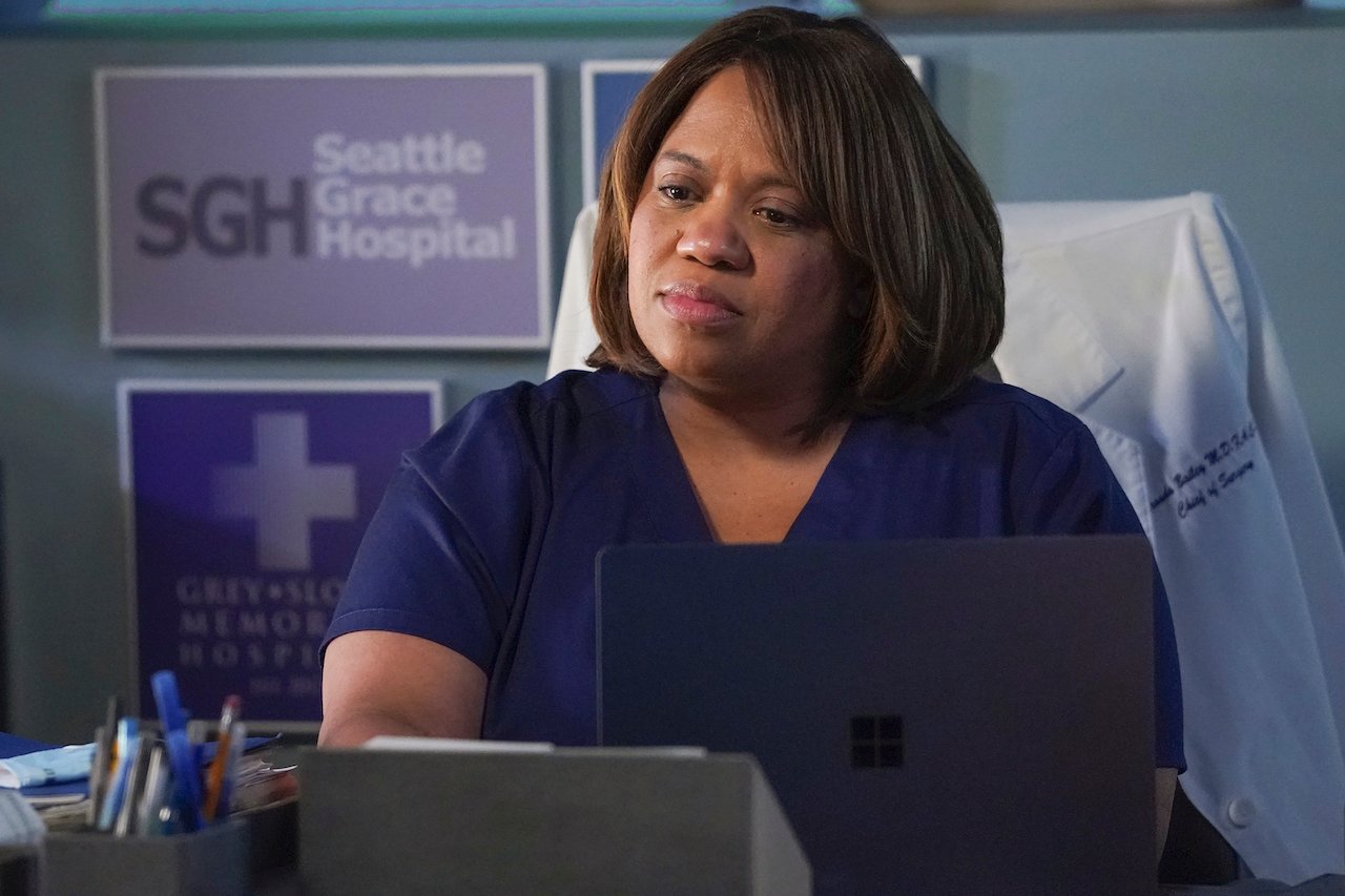 Chandra Wilson as Miranda Bailey on 'Grey's Anatomy' sits down looking at a laptop.