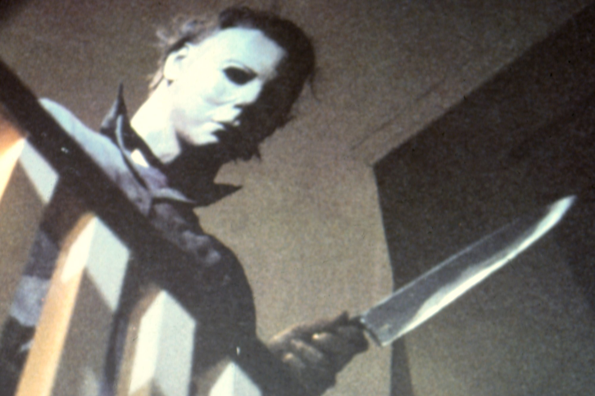 'Halloween' Michael Myers with chef's knife leaning over bannister
