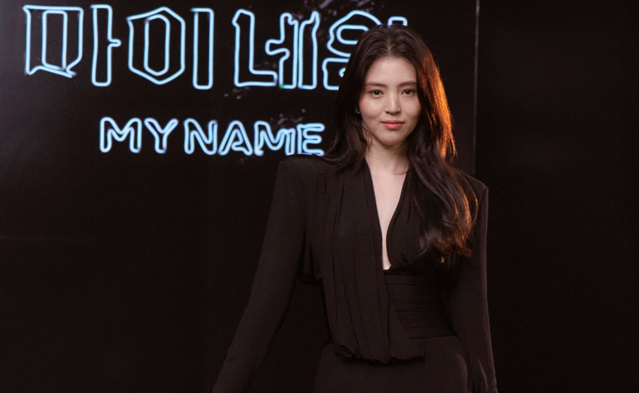 Han So-Hee for 'My Name' Netflix K-drama press event wearing black dress in front of illuminated sign