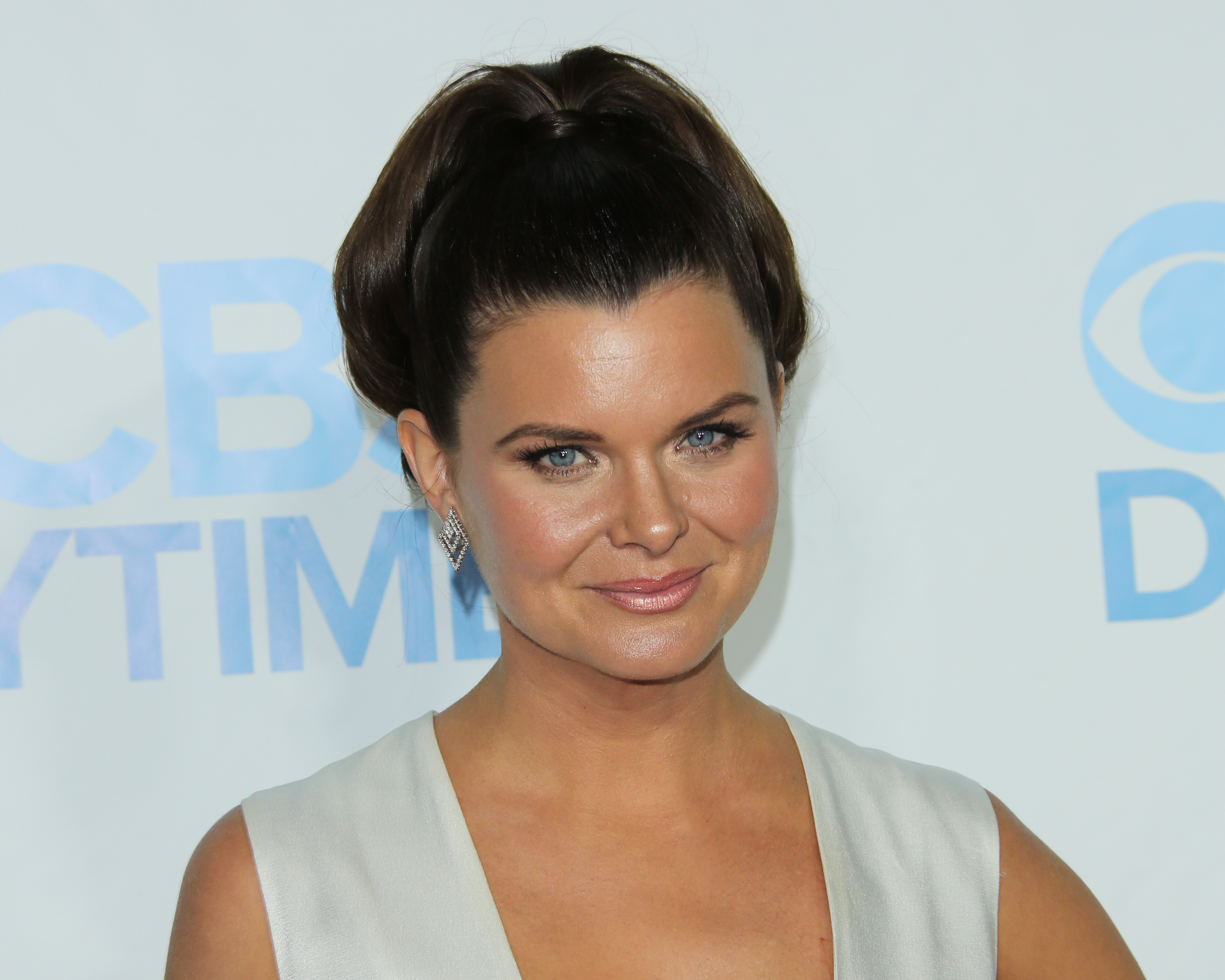 'The Bold and the Beautiful' actor Heather Tom wears a white dress and poses for photographers on the red carpet.