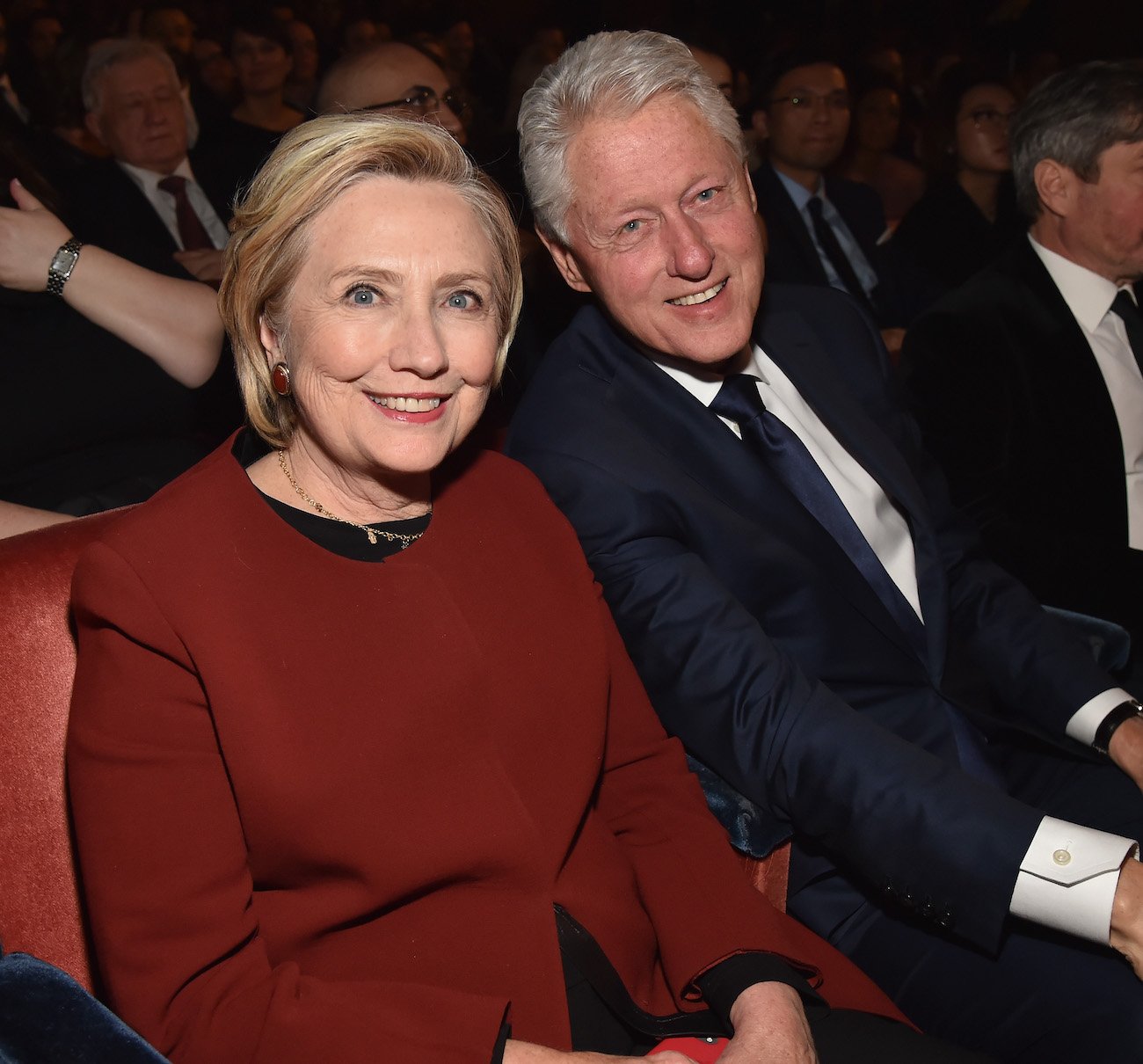 Hillary Clinton and Bill Clinton smile as they sit together at the 2018 Grammy Awards