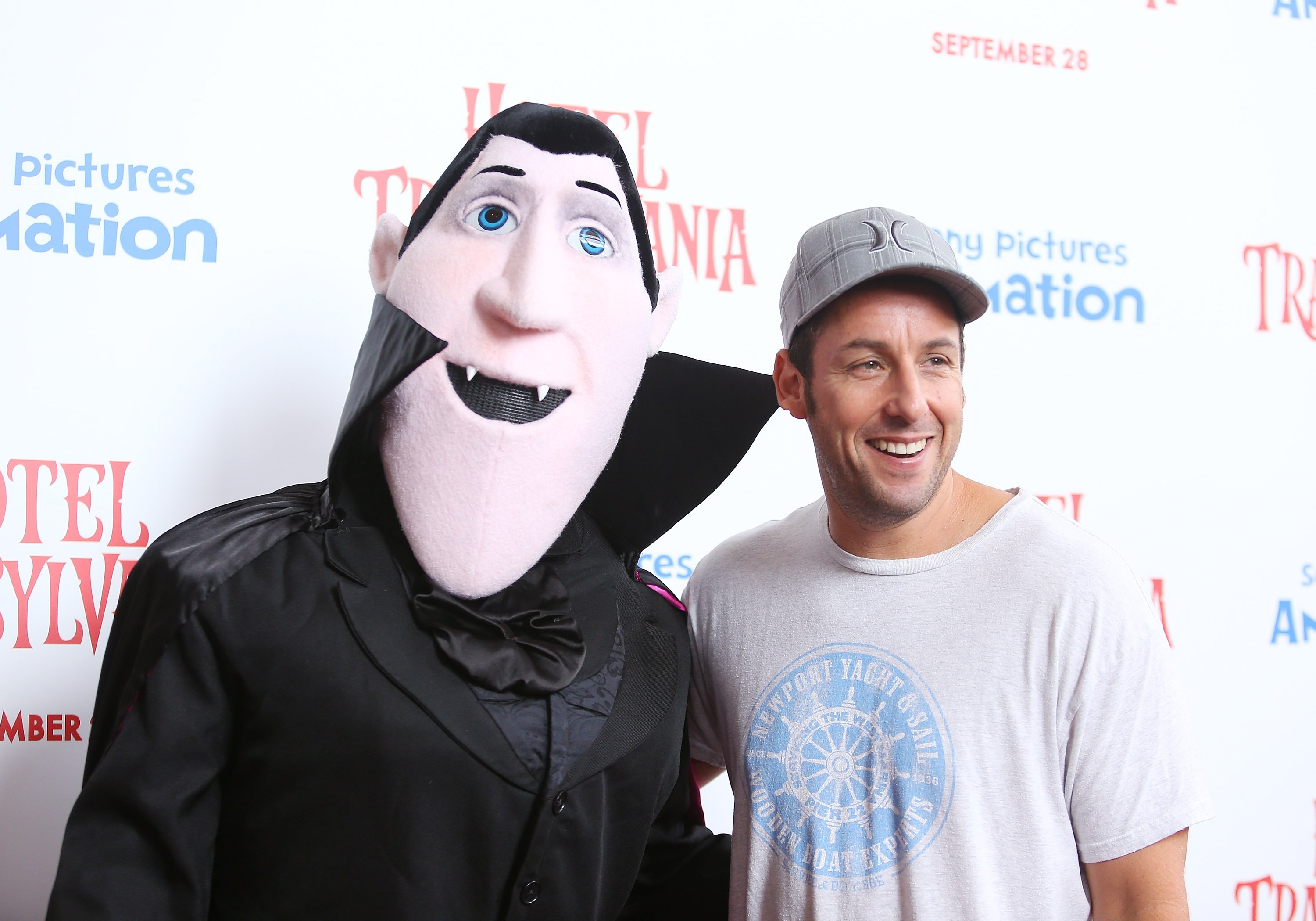 Adam Sandler poses next to his character Drac from Hotel transylvania