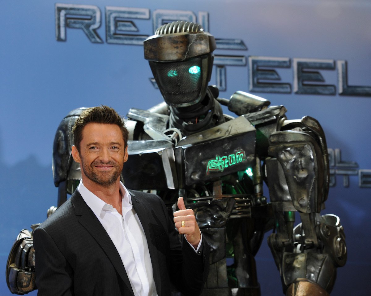 Hugh Jackman wearing a suit with a robot from 'Real Steel'
