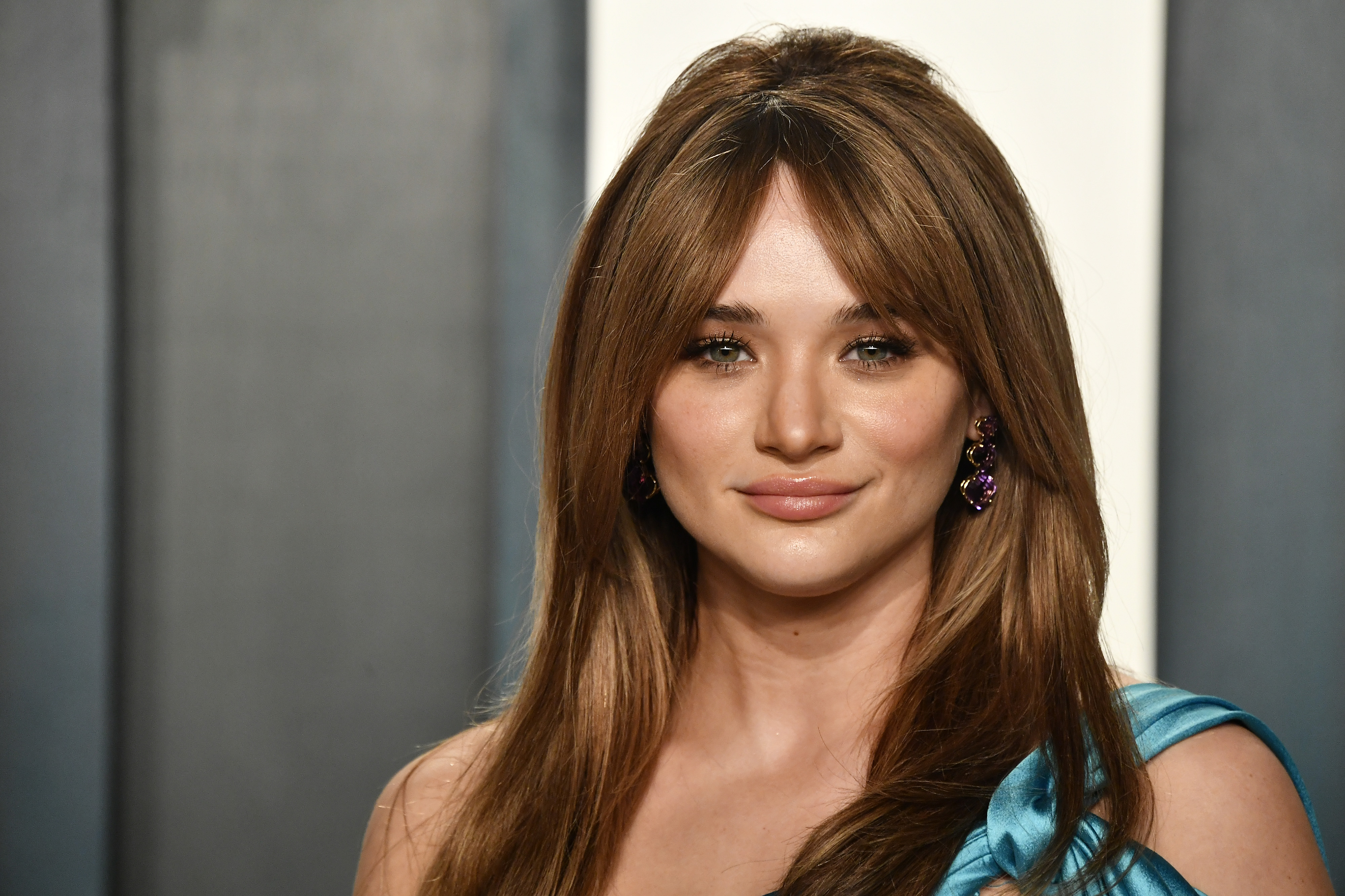 'The Young and the Restless' actor Hunter King wearing a blue dress and smiling for photographers at a Vanity Fair Oscar party.