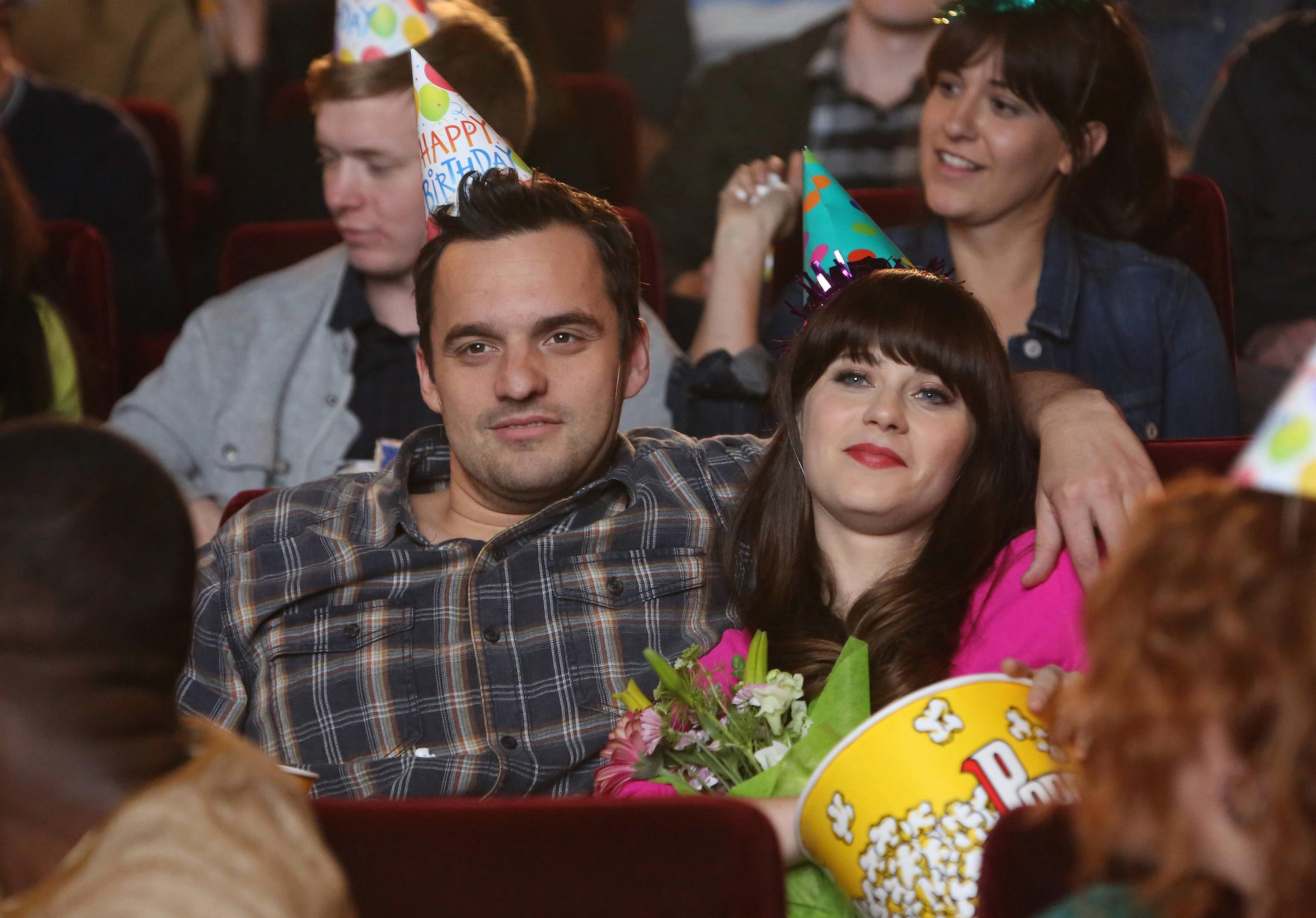 Jake Johnson, and Zooey Deschanel watching a movie in 'New Girl.'