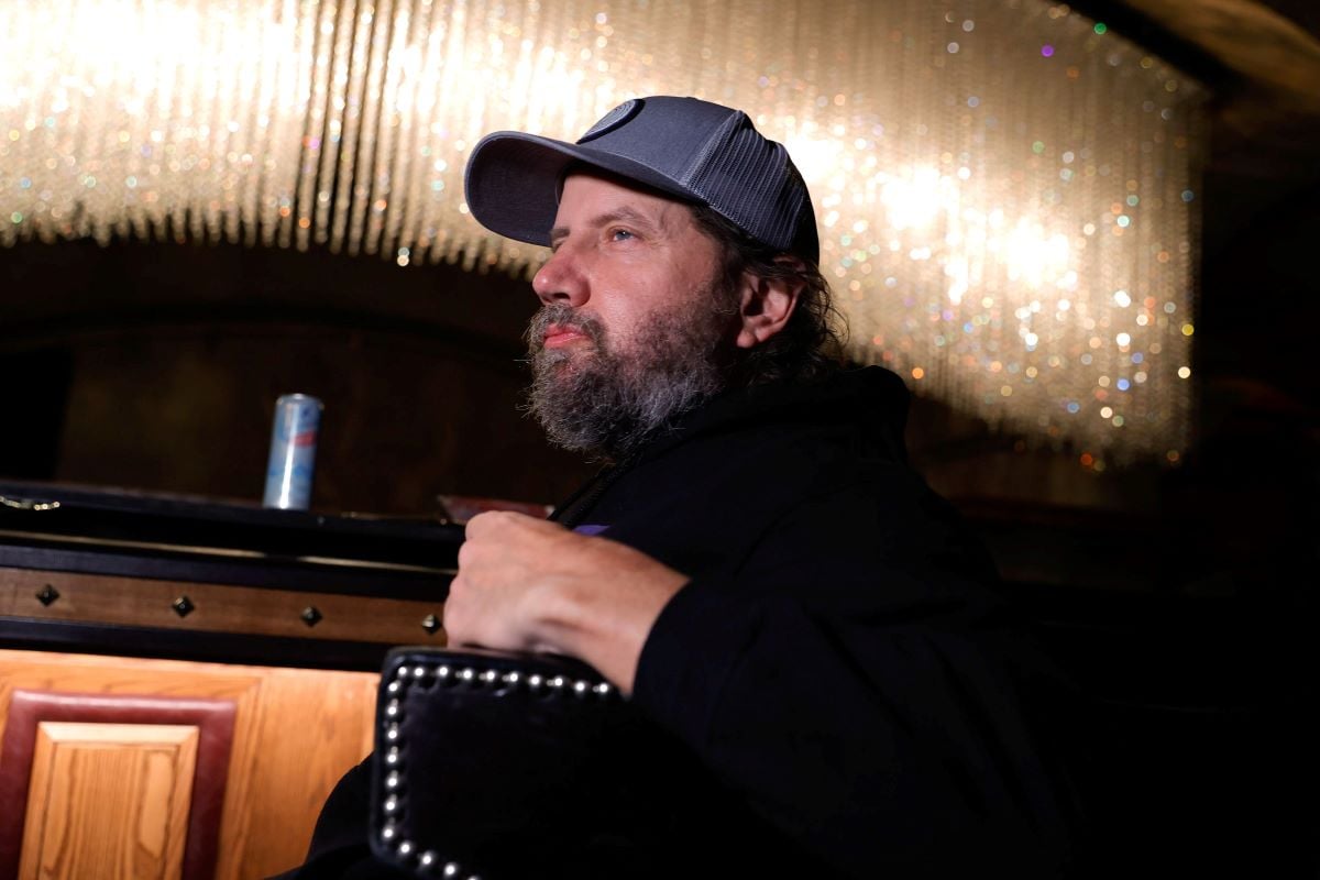 Jamie Kennedy from the side with a beard and cap.