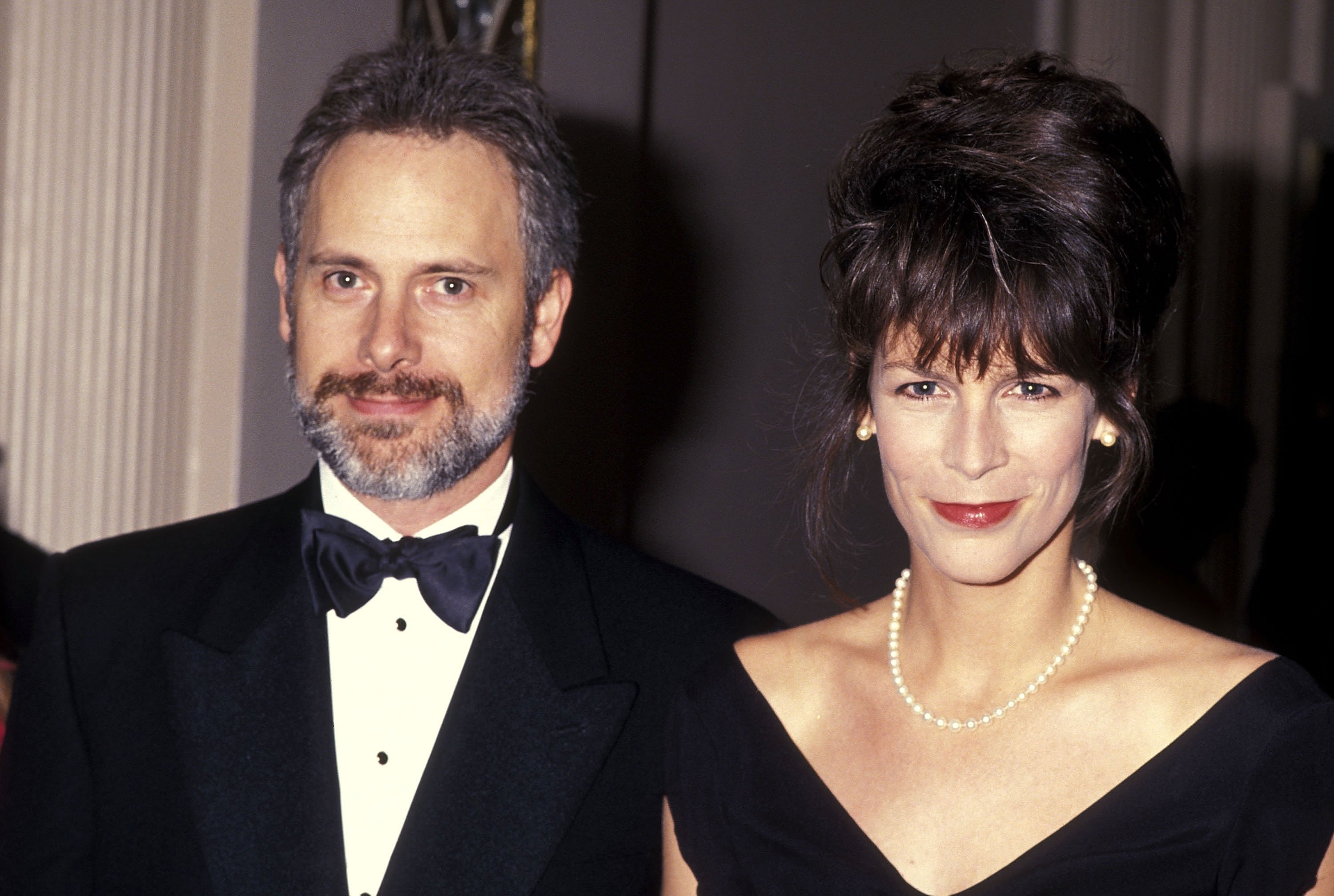 Christopher Guest and Jamie Lee Curtis wearing black and standing together.