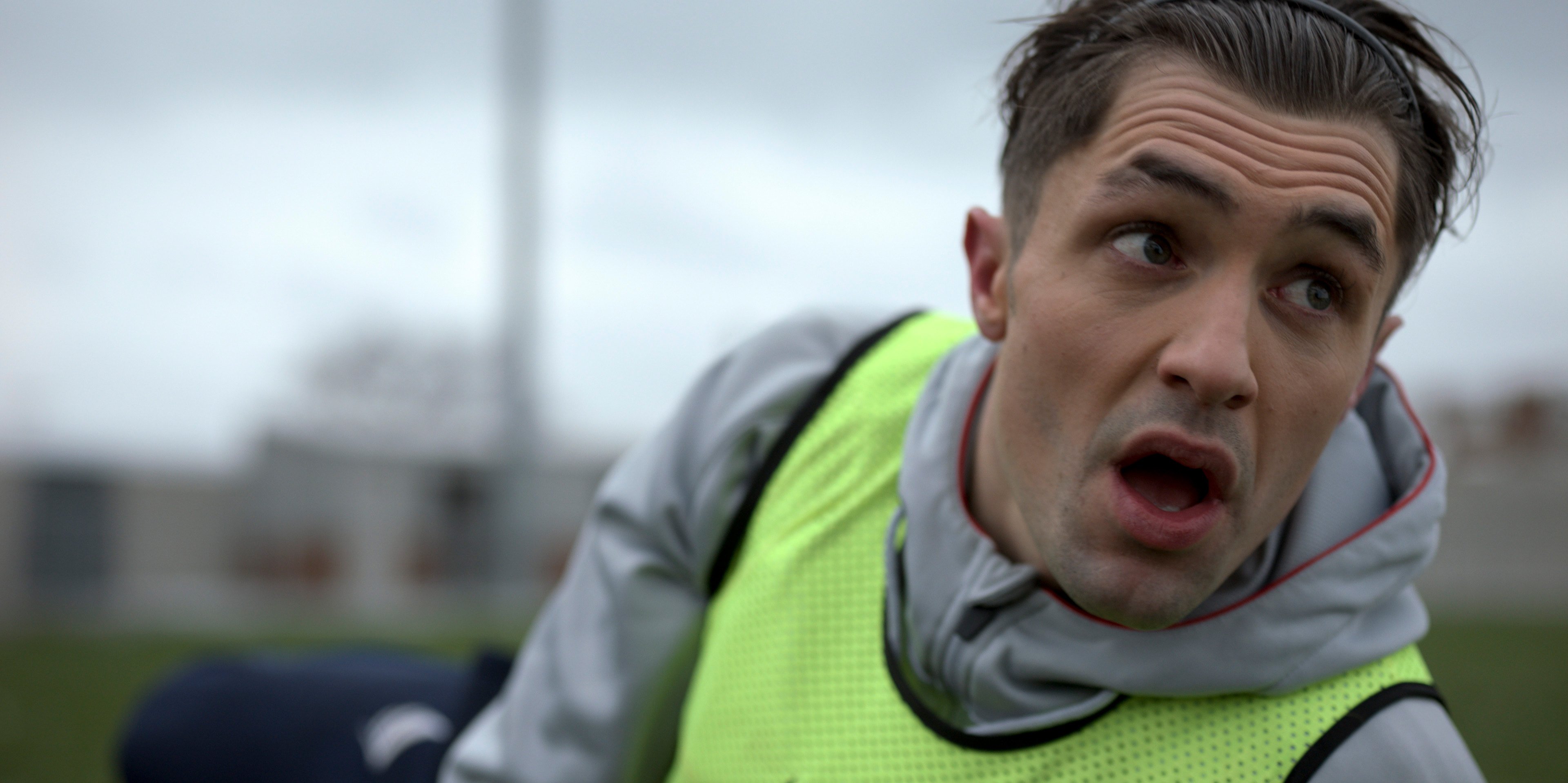 Phil Dunster as Jamie Tartt lying on the soccer field in a neon yellow practice vest In a season 2 episode of the Apple TV+ series 'Ted Lasso'