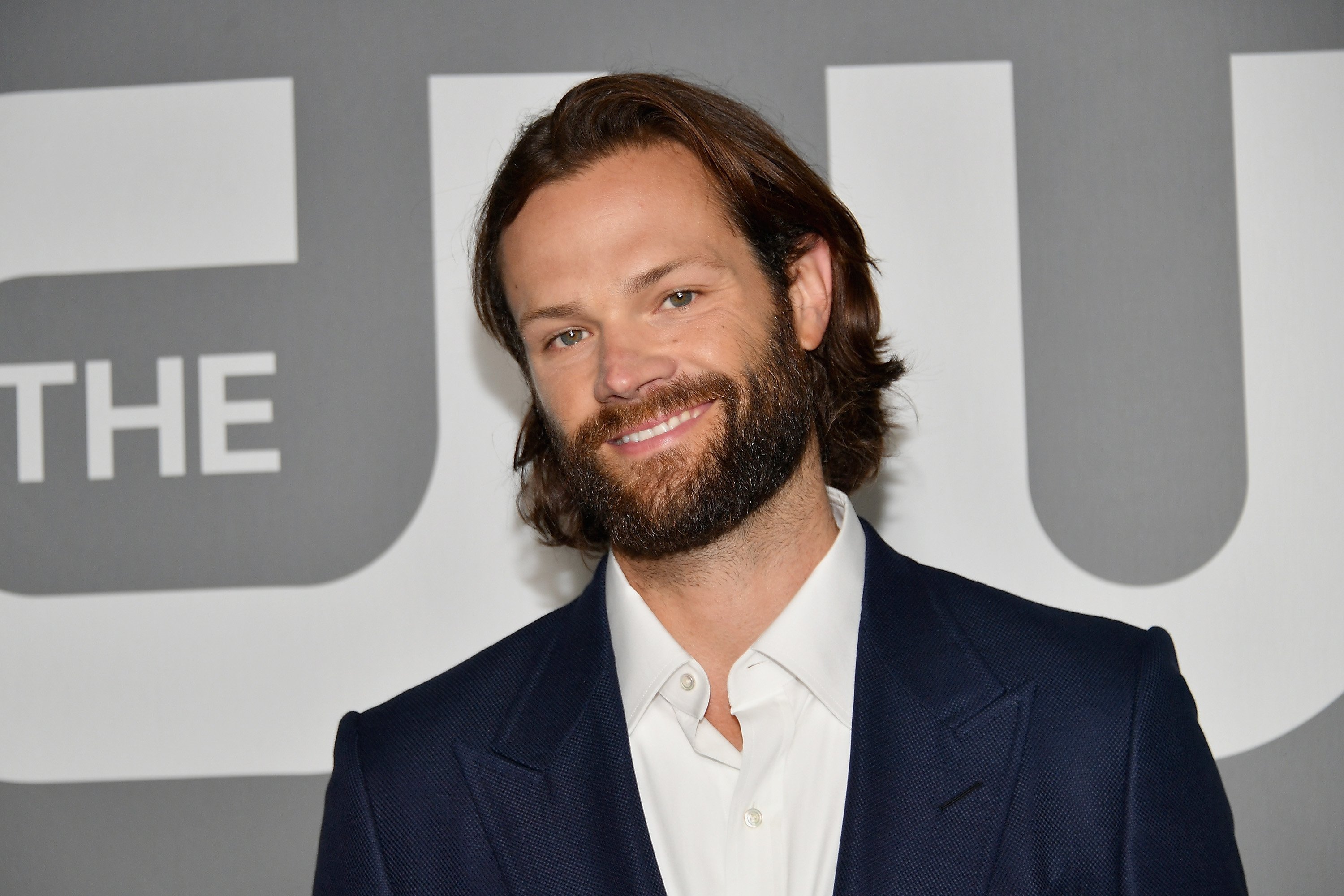 'Gilmore Girls' alum Jared Padalecki smiles as he stands in a suit on a red carpet.