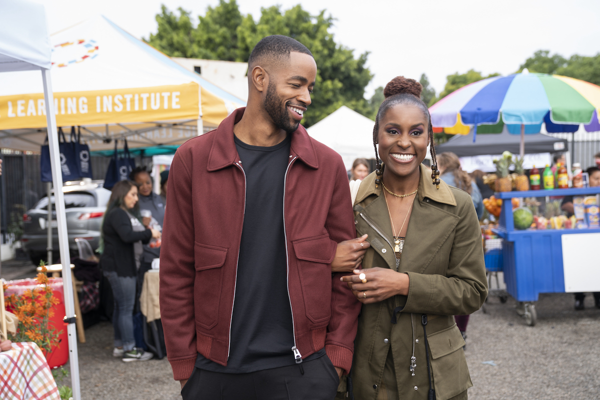 Jay Ellis as Lawrence and Issa Rae as Issa smiling and walk arm-in-arm on 'Insecure'