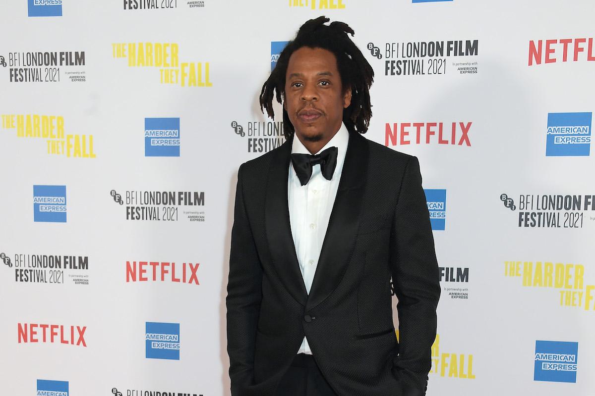 Jay-Z in front of a white backdrop with logos