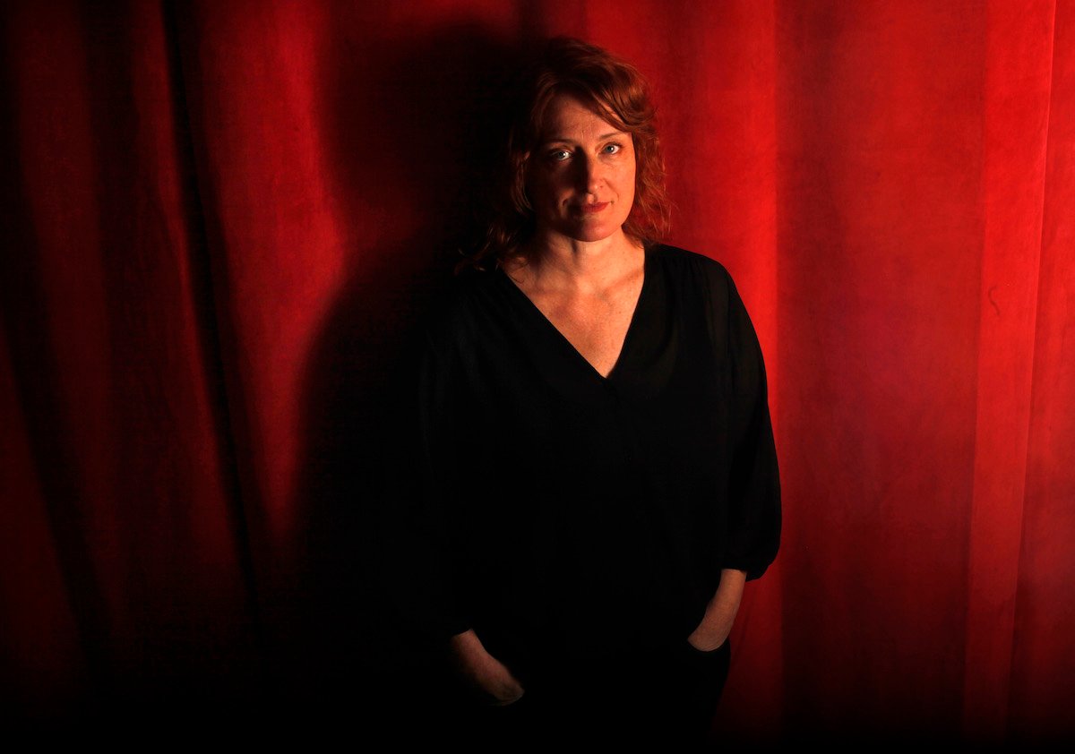 Jennifer Kent, horror movie director, in black with red curtain