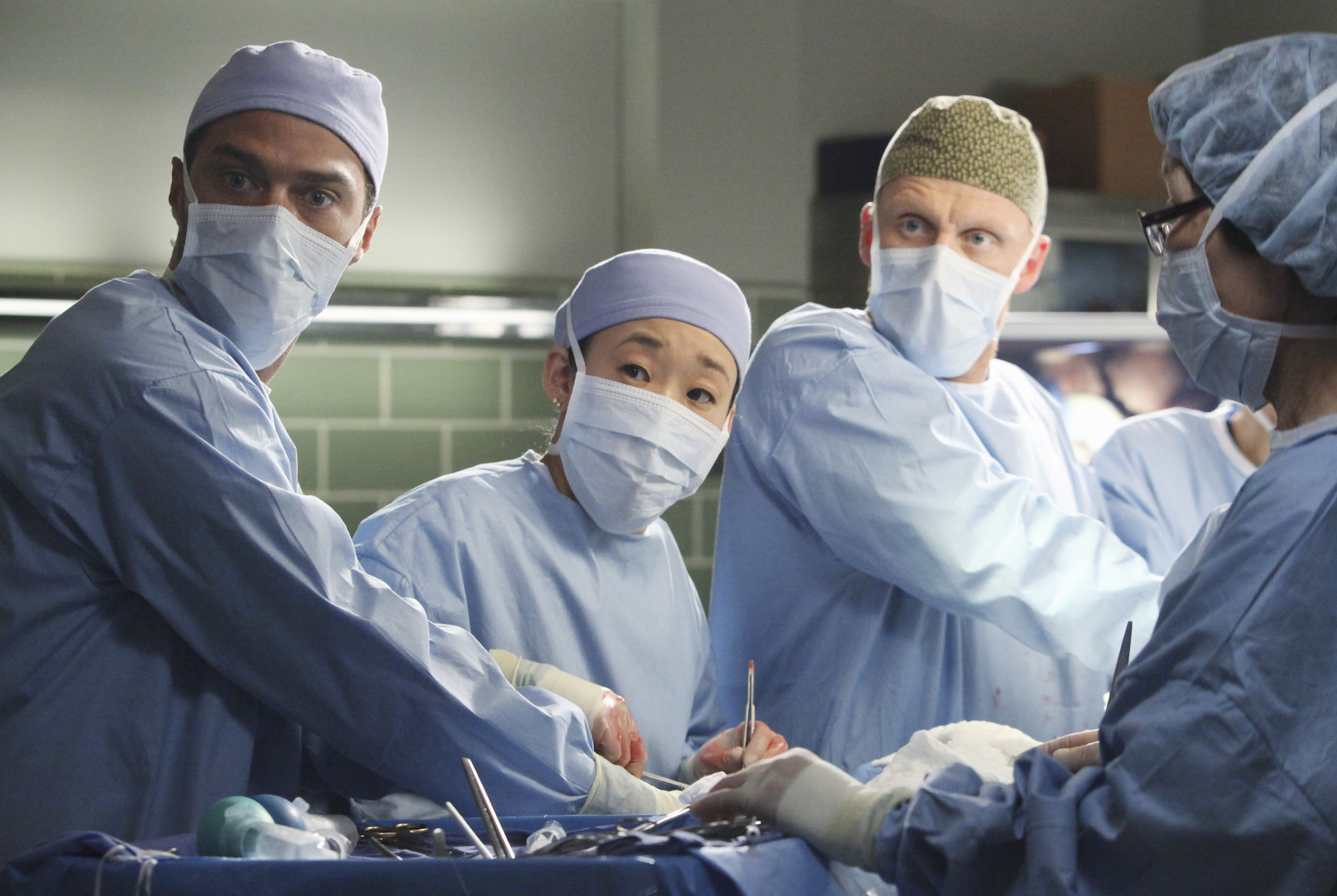 Jessie Williams, Sandra Oh and Kevin McKidd dressed in hospital scrubs in 'Grey's Anatomy.'