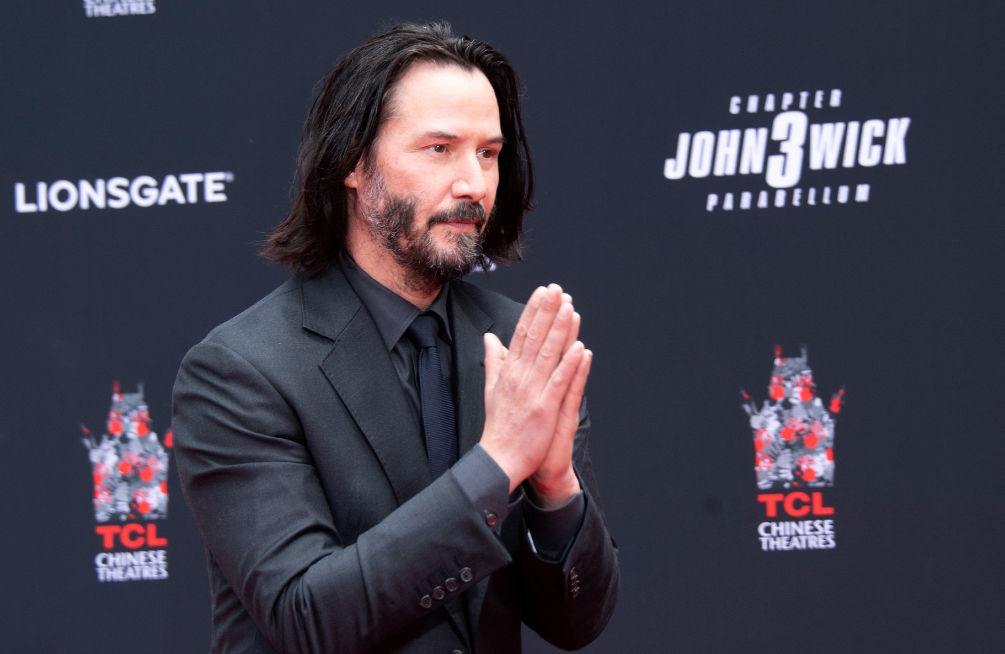 'John Wick 4' star Keanu Reeves at the TCL Chinese Theatre with his hands clasped