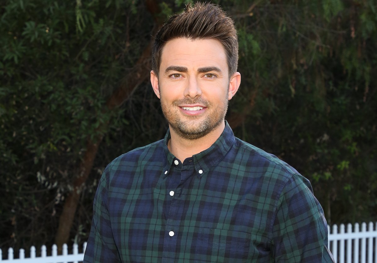 Jonathan Bennett smiles for the camera wearing a plaid shirt.