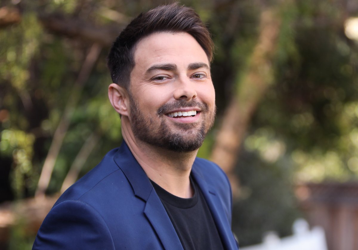 Jonathan Bennett smiles for the camera wearing a blue jacket.