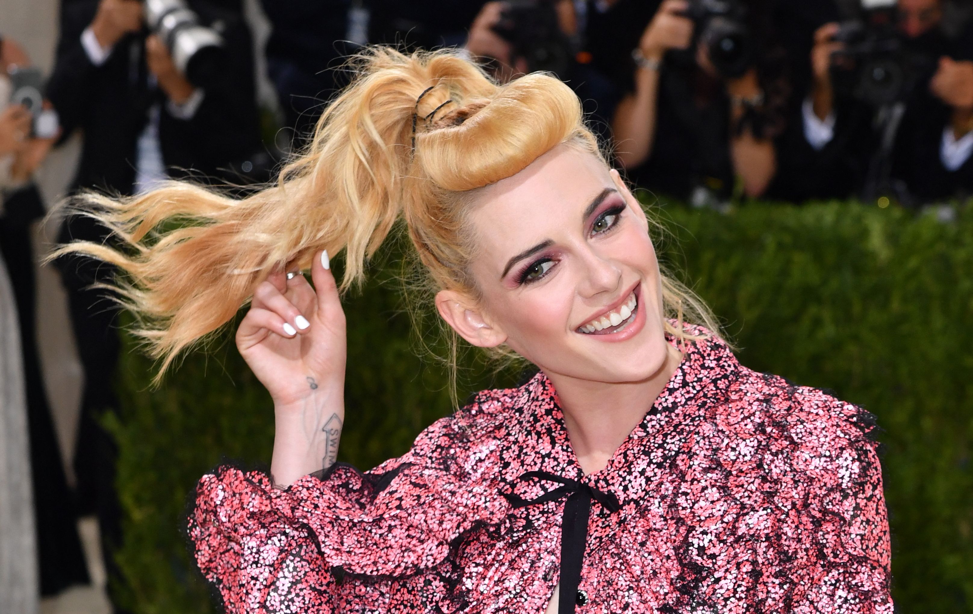 Kristen Stewart, star of the new Spencer movie, flips her ponytail hair at the Met Gala