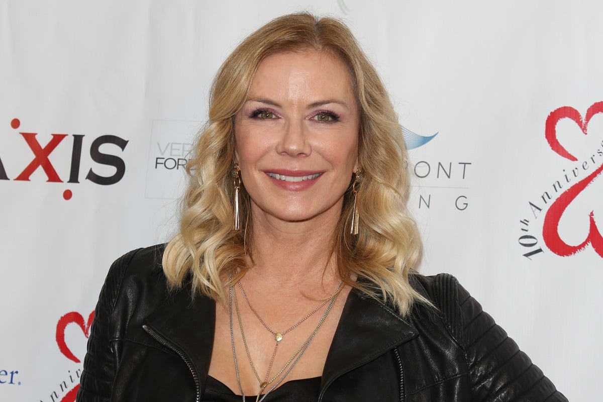 'The Bold and the Beautiful' actor Katherine Kelly Lang in a black blouse and leather jacket, smiling for photographers on the red carpet.