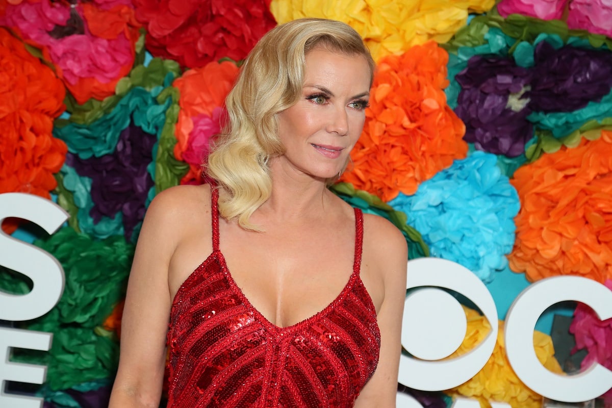 'The Bold and the Beautiful' actor Katherine Kelly Lang wearing a red dress and posing in front of a floral backdrop.