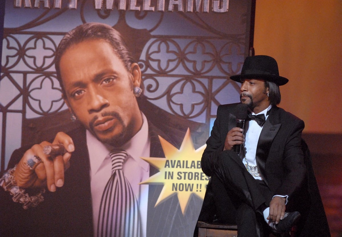 Katt Williams sitting in front of picture of himself