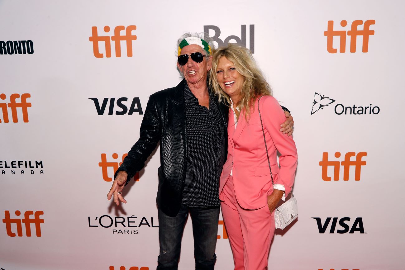 Keith Richards in a black outfit and Patti Hansen in a pink outfit.