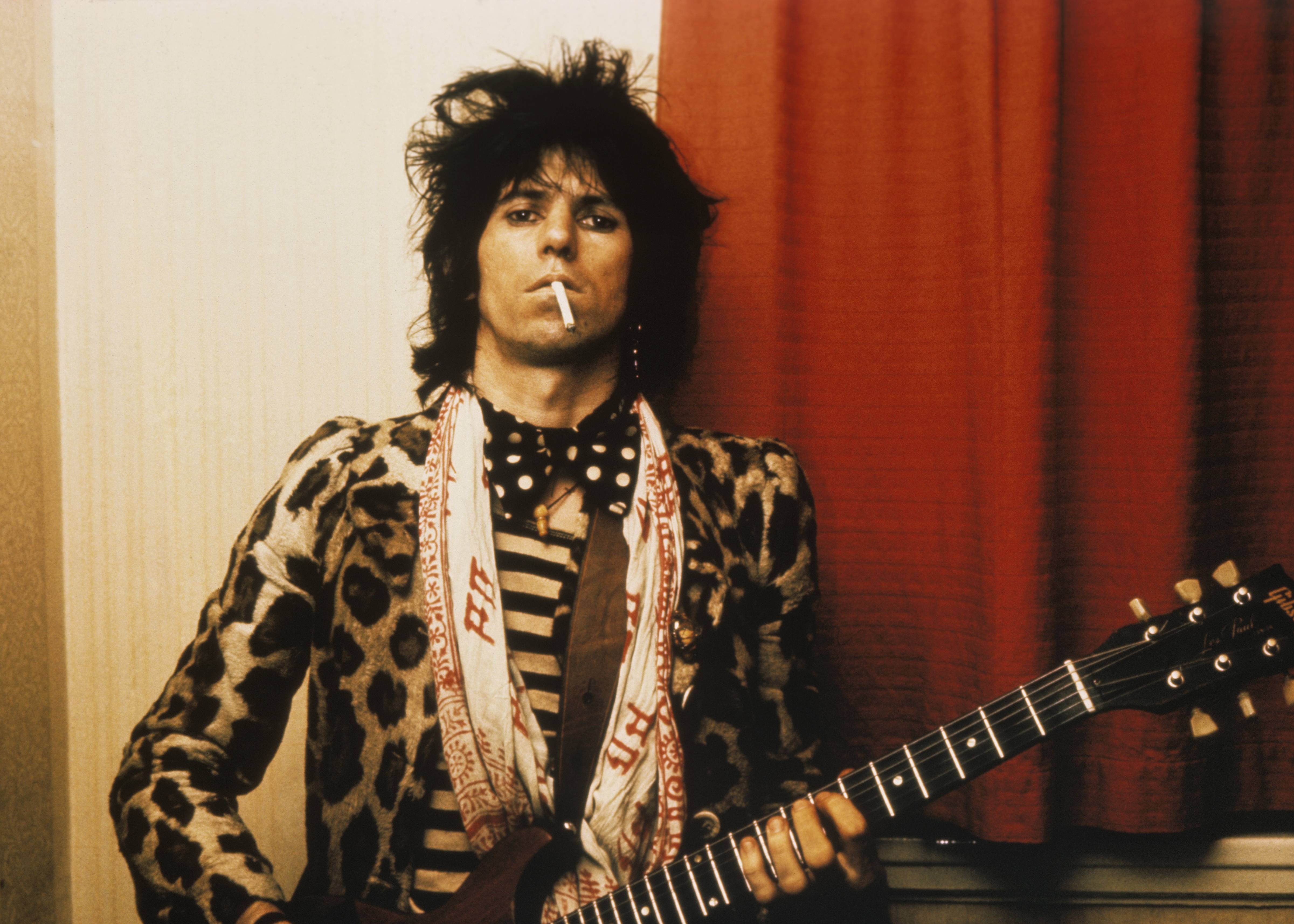 The Rolling Stones guitarist Keith Richards with a guitar and a cigarette.