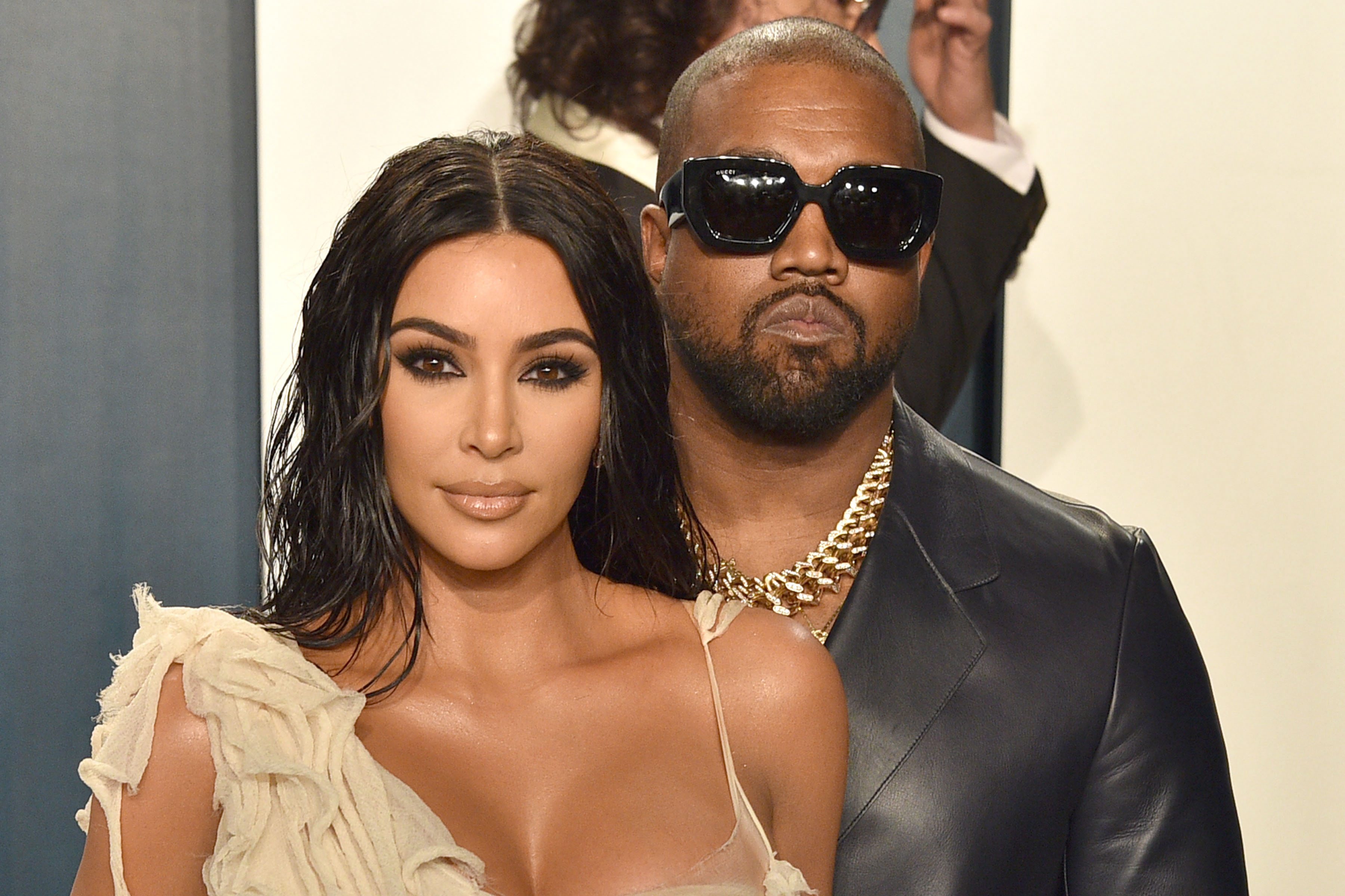 Kim Kardashian and Kanye West attend the 2020 Vanity Fair Oscar Party with Kim posing in front of Kanye