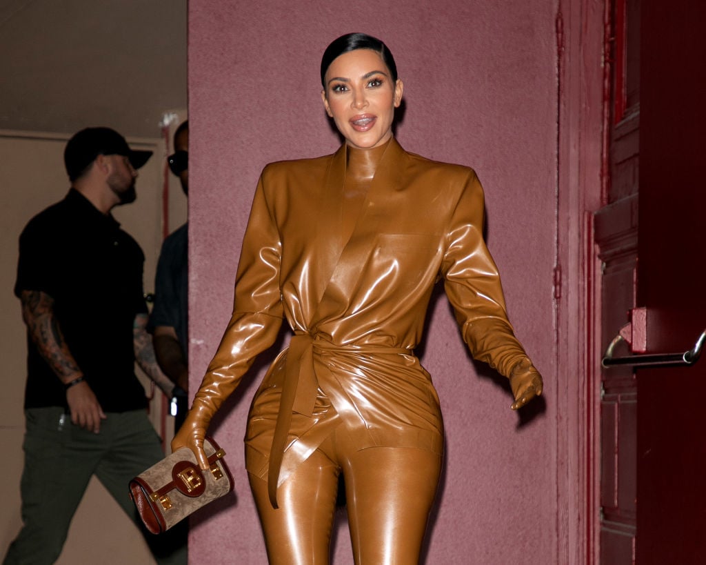 Kim Kardashian West is dressed in a tan, vinyl-looking outfit as she leaves an event.