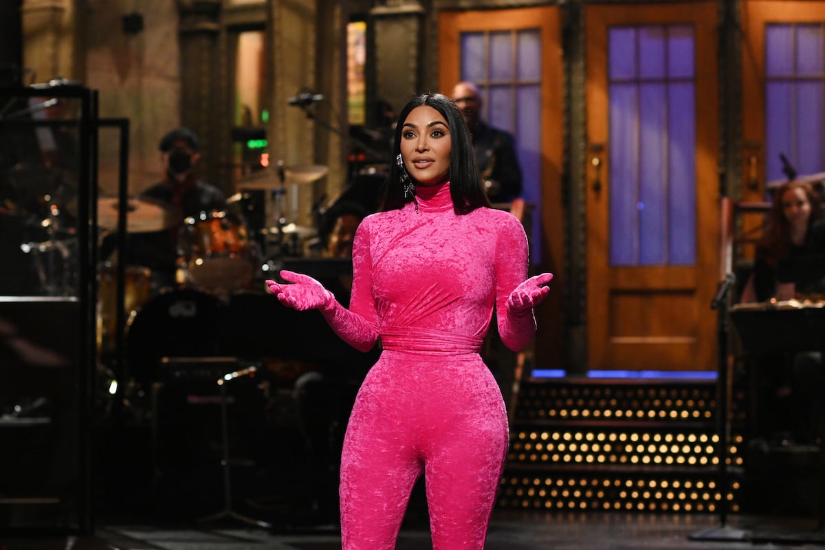 Kim Kardashian West on the "Saturday Night Live" stage wearing a pink velvet jumpsuit.