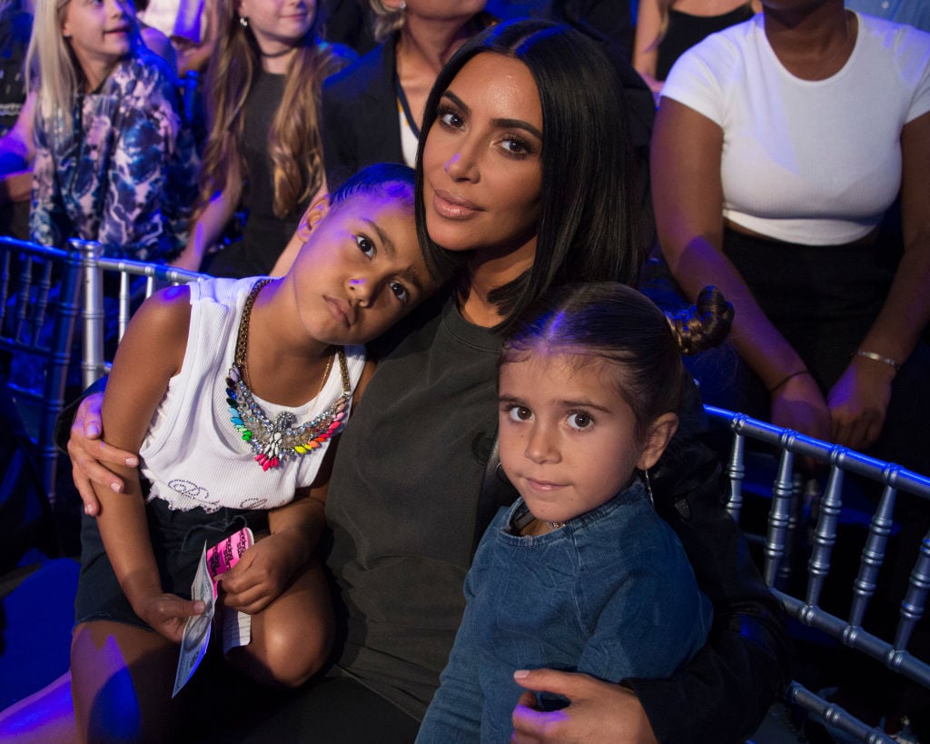 Kim Kardashian West poses with two of her children while sitting in the audience of 'Dancing with the Stars'.