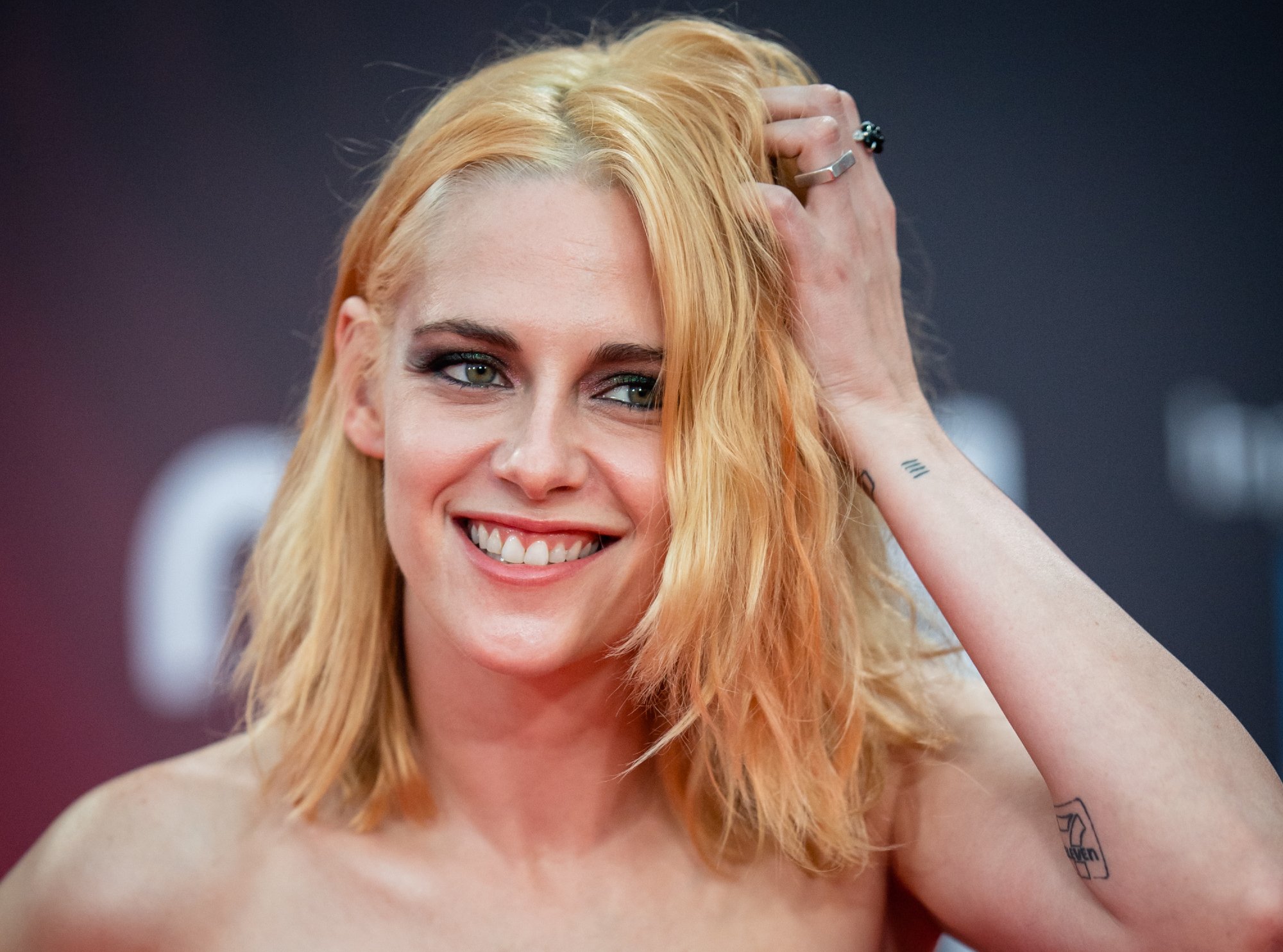 Kristen Stewart at the 'Spencer' UK premiere smiling with her hand in her hair