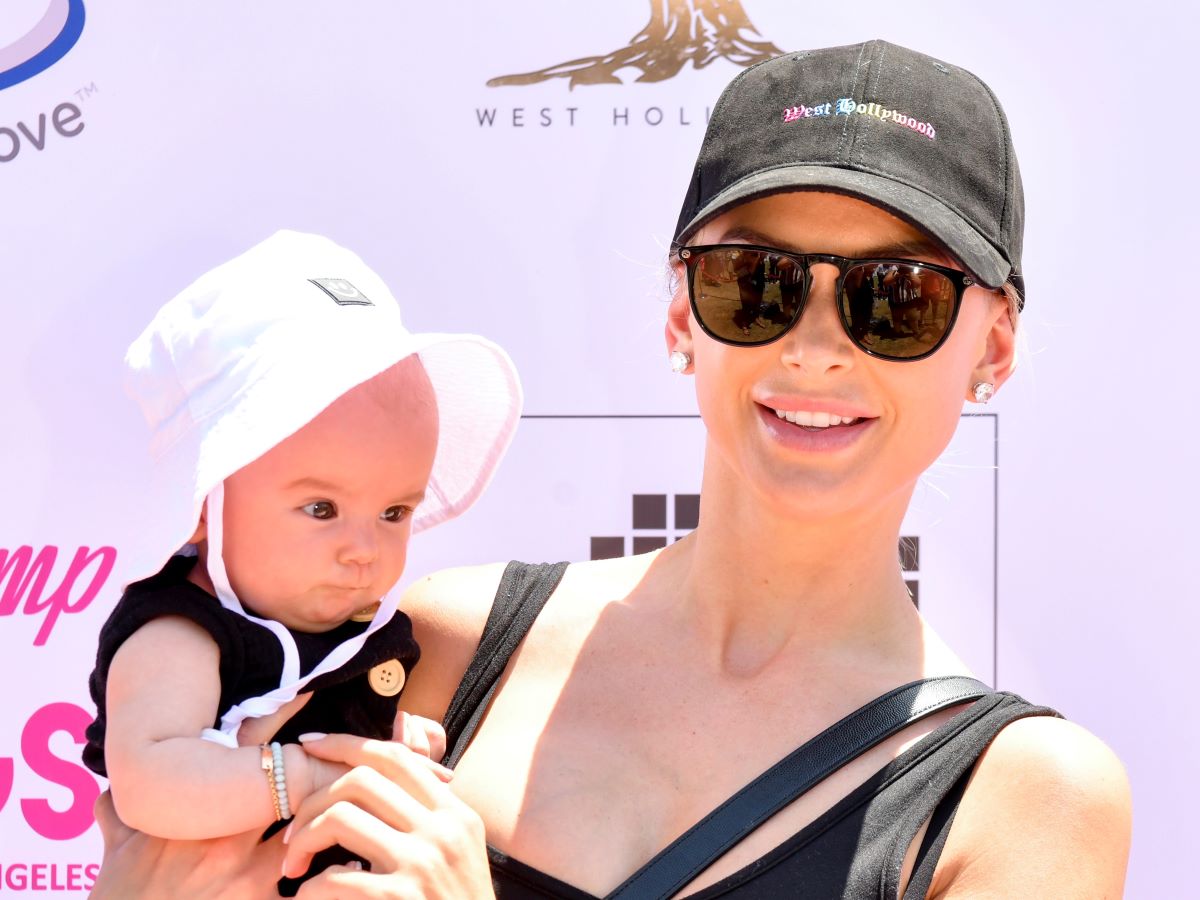 Lala Kent in cap and sunglasses holding baby daughter
