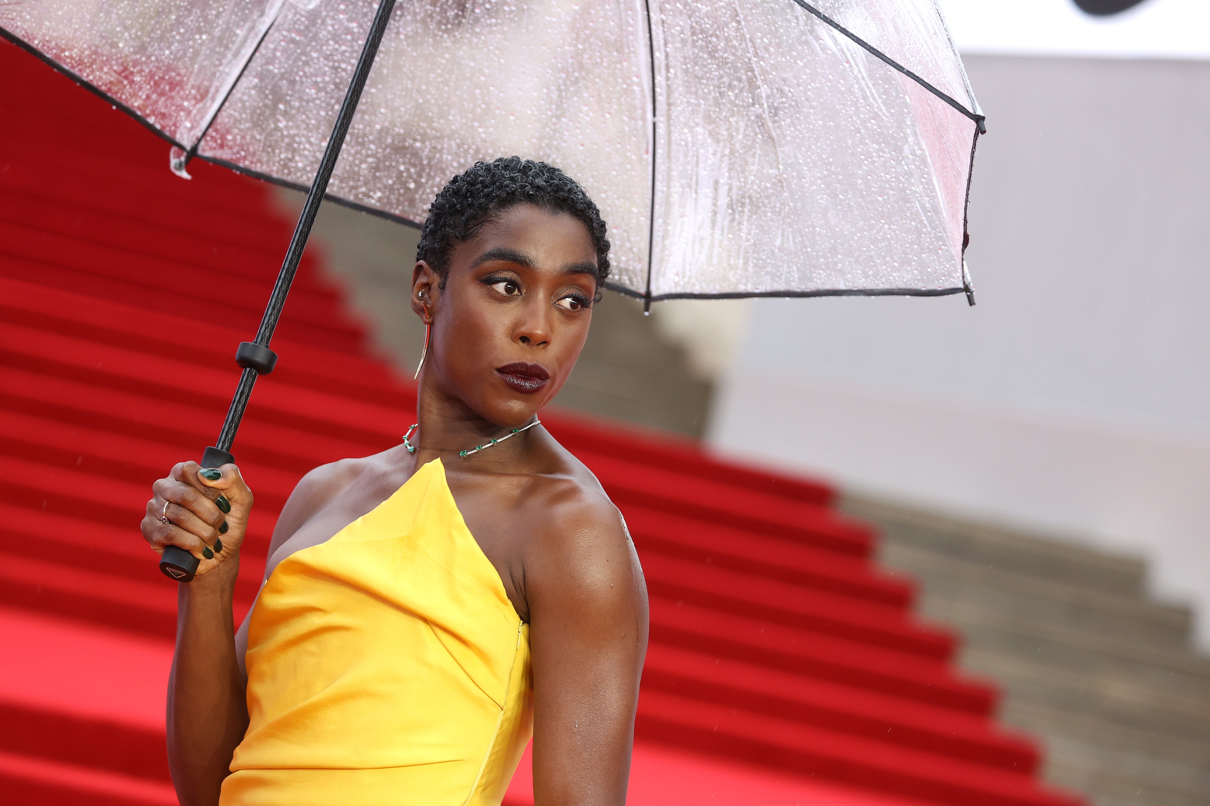 Lashana Lynch, star of the new James Bond movie, poses with an umbrella on the red carpet