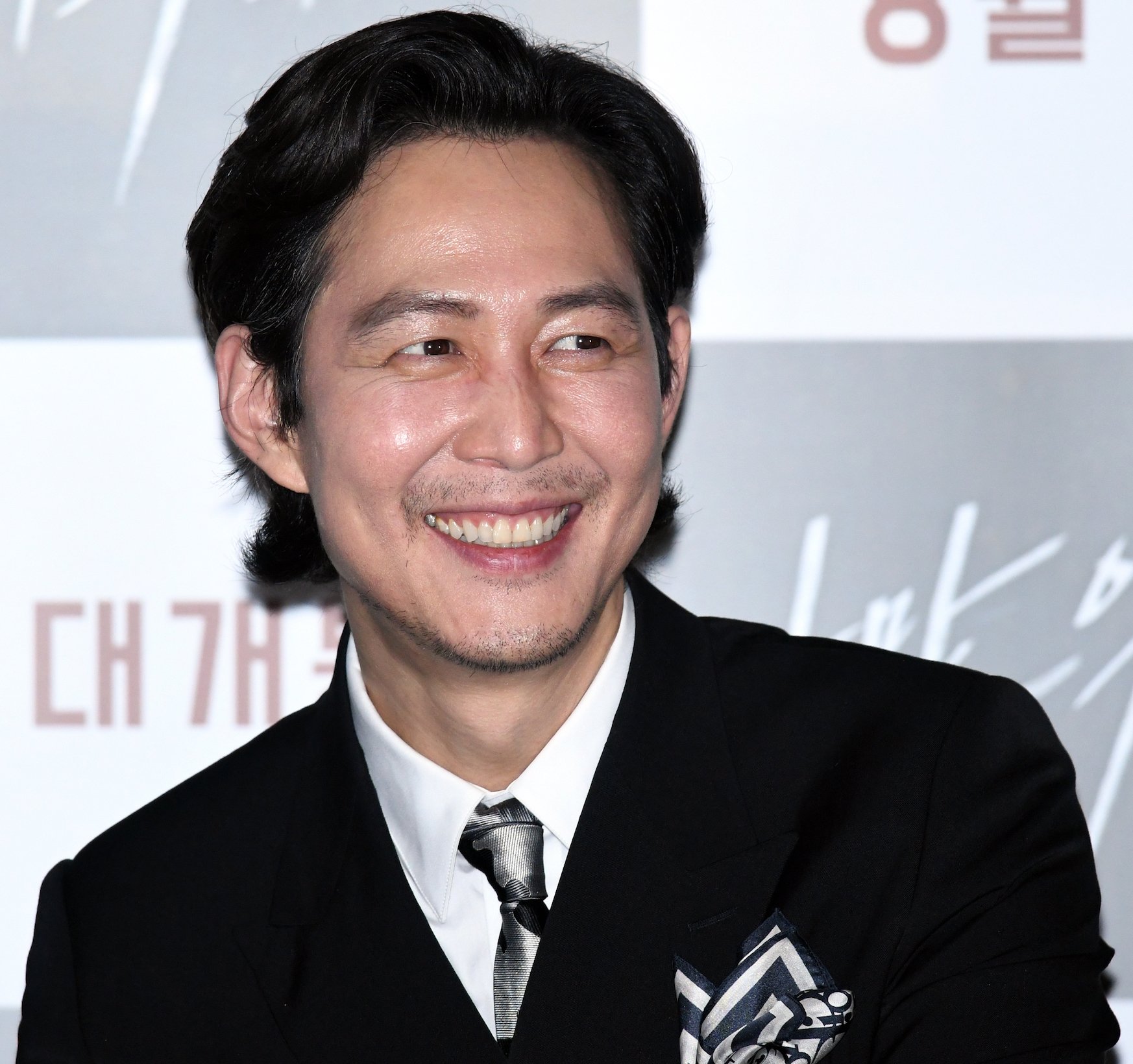 Lee Jung-jae smiling at a press conference. He played Gi-hun in the 'Squid Game' cast and said he would take part in 'Squid Game' Season 2