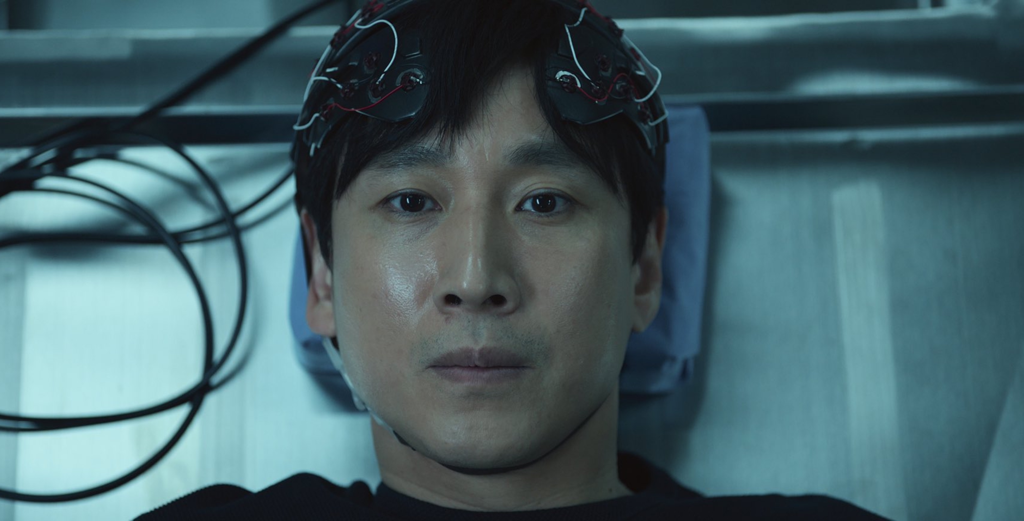 Lee Sun-kyun as Sewon for 'Dr. Brain' for Apple TV+ sitting on metal table