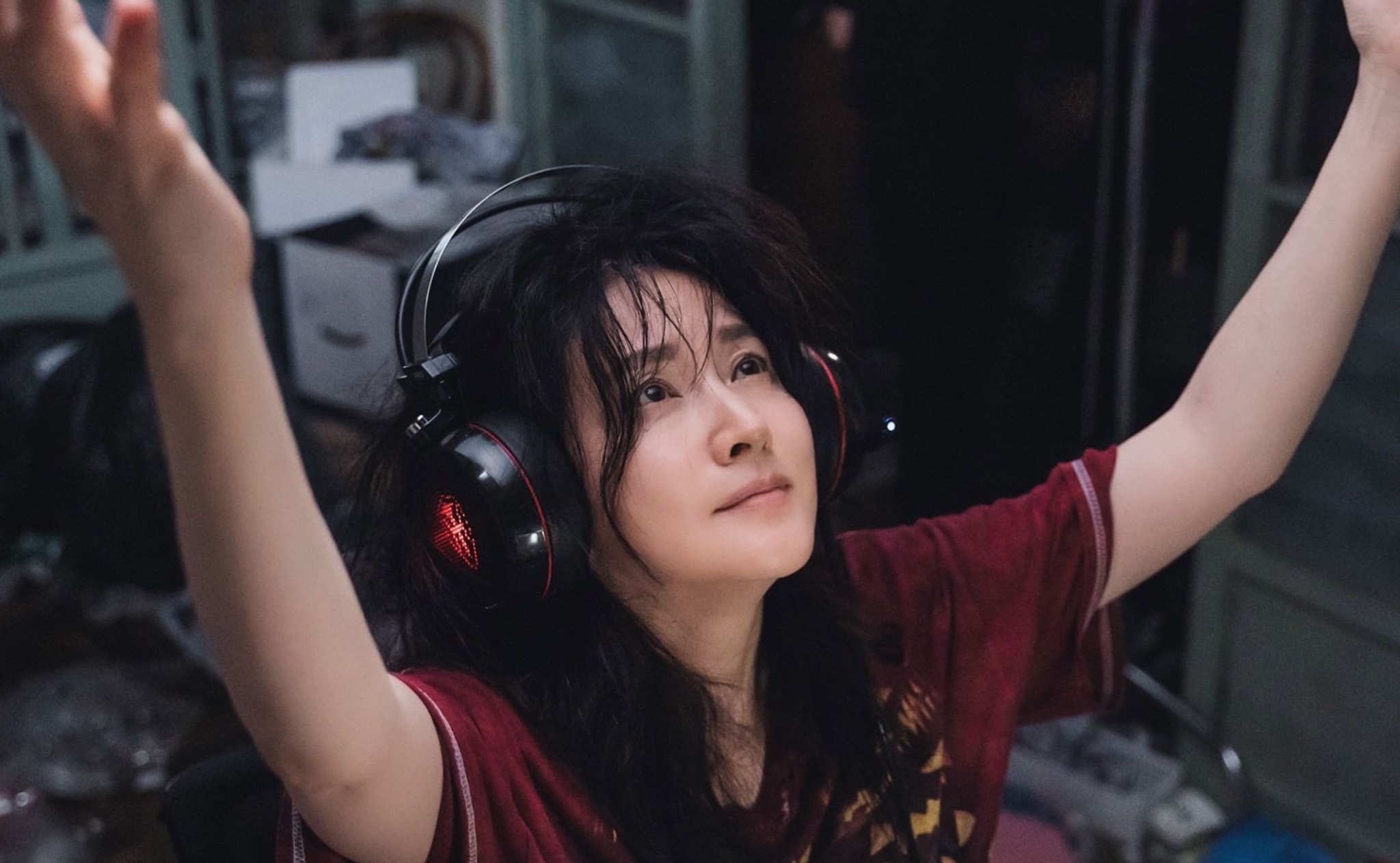 Lee Young-Ae as Koo Kyung-Yi for 'Inspector Koo' K-drama in red shirt, gaming headphones and raising her arms.