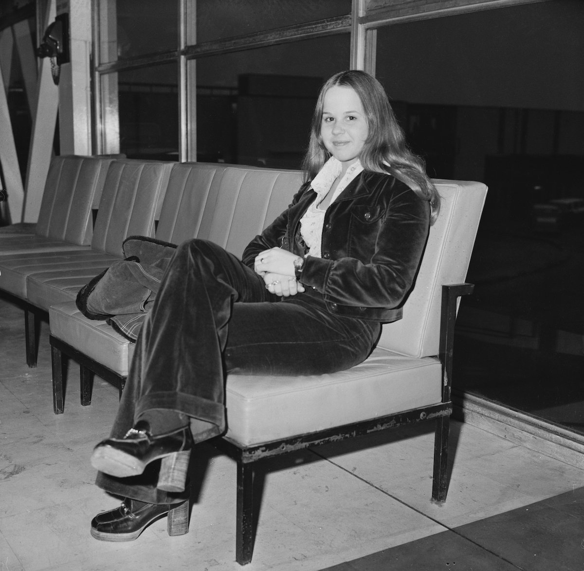 Linda Blair smiling, seated, in a black and white photo from 1974