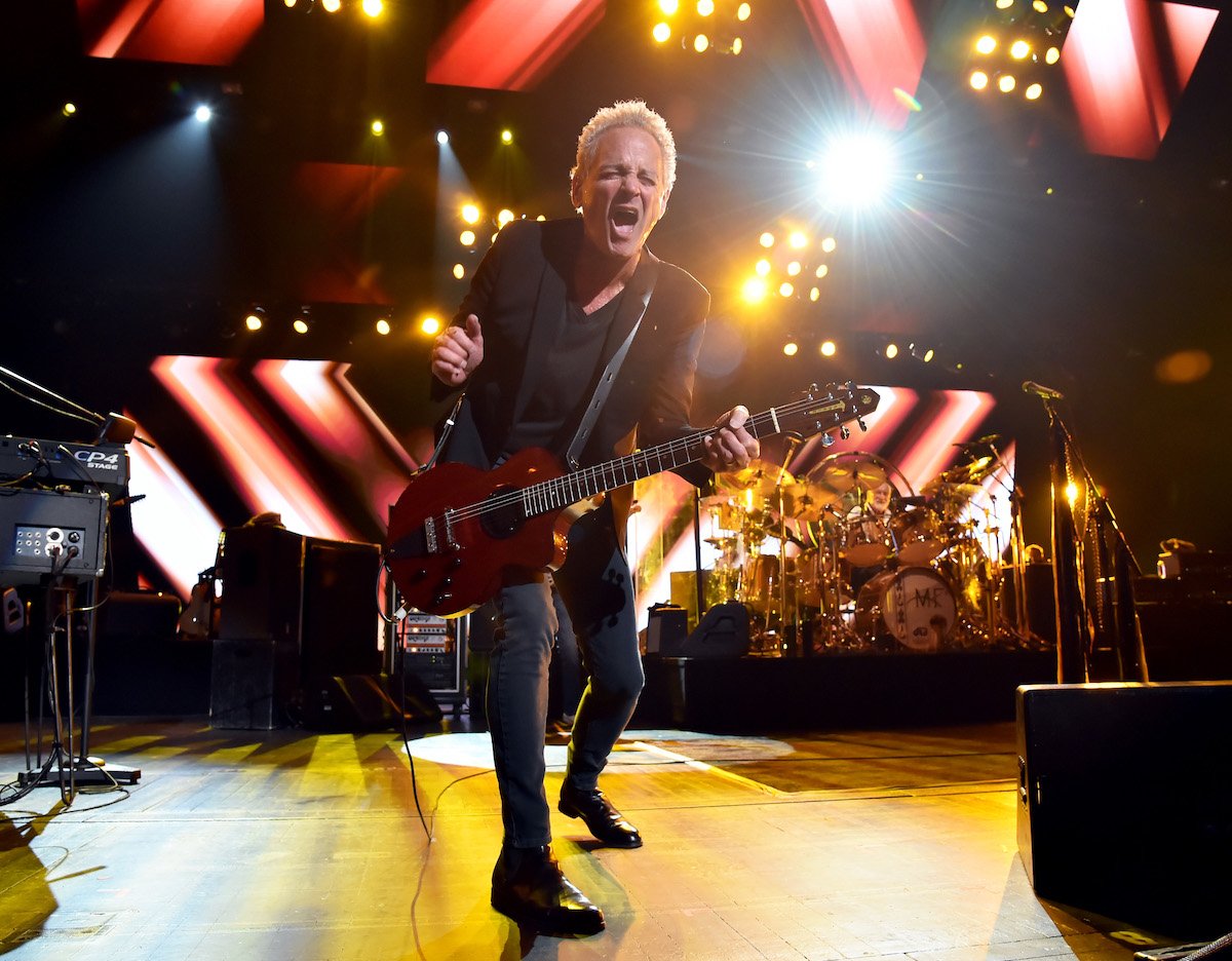 Lindsey Buckingham plays the guitar on stage.